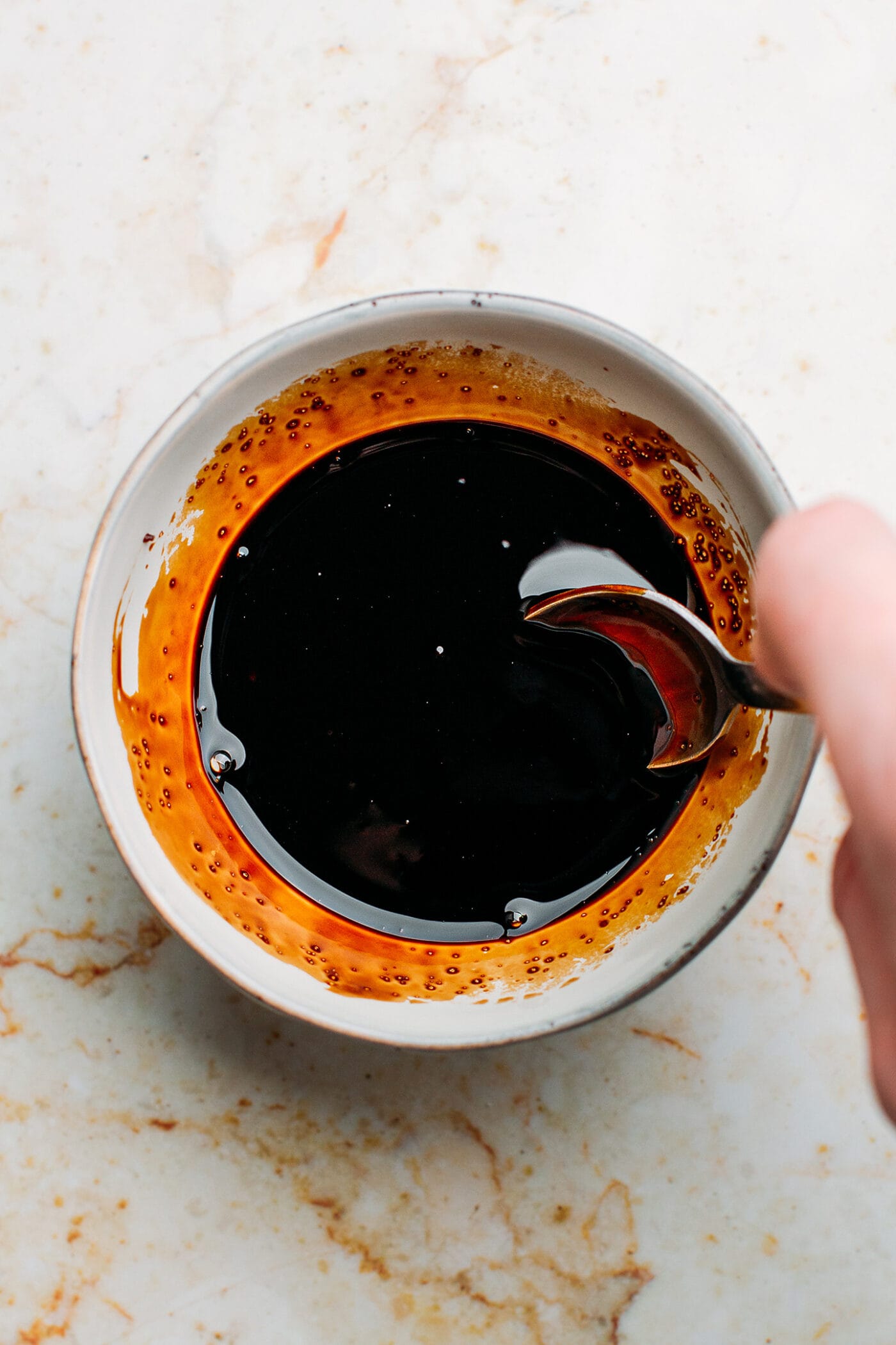 Stirring Lo Mein sauce in a small bowl.