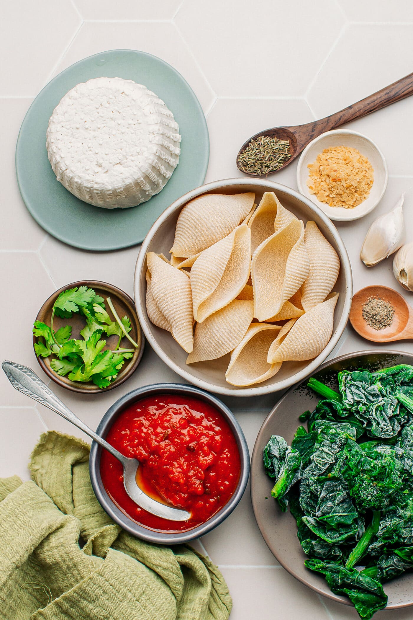 Ingredients like ricotta, jumbo shells, spinach, and tomato sauce.