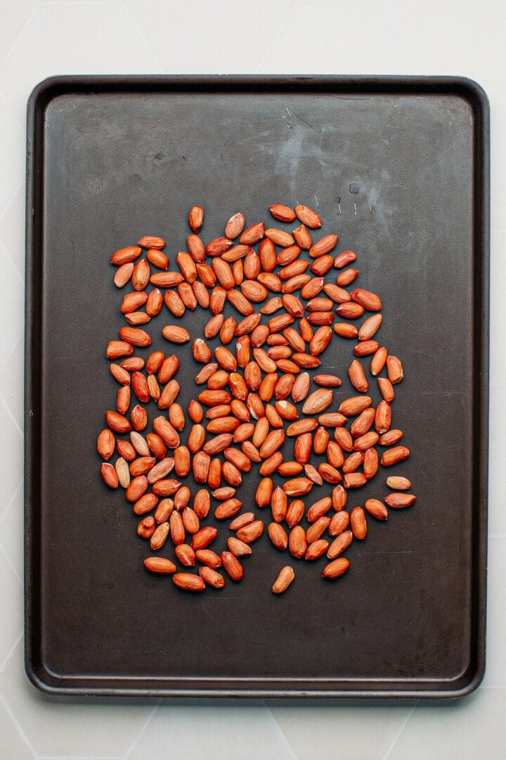 Raw peanuts on a baking sheet.