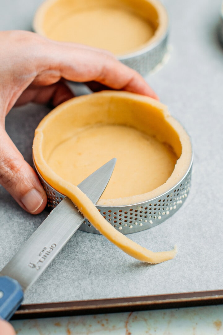 Trimming dough using a knife.