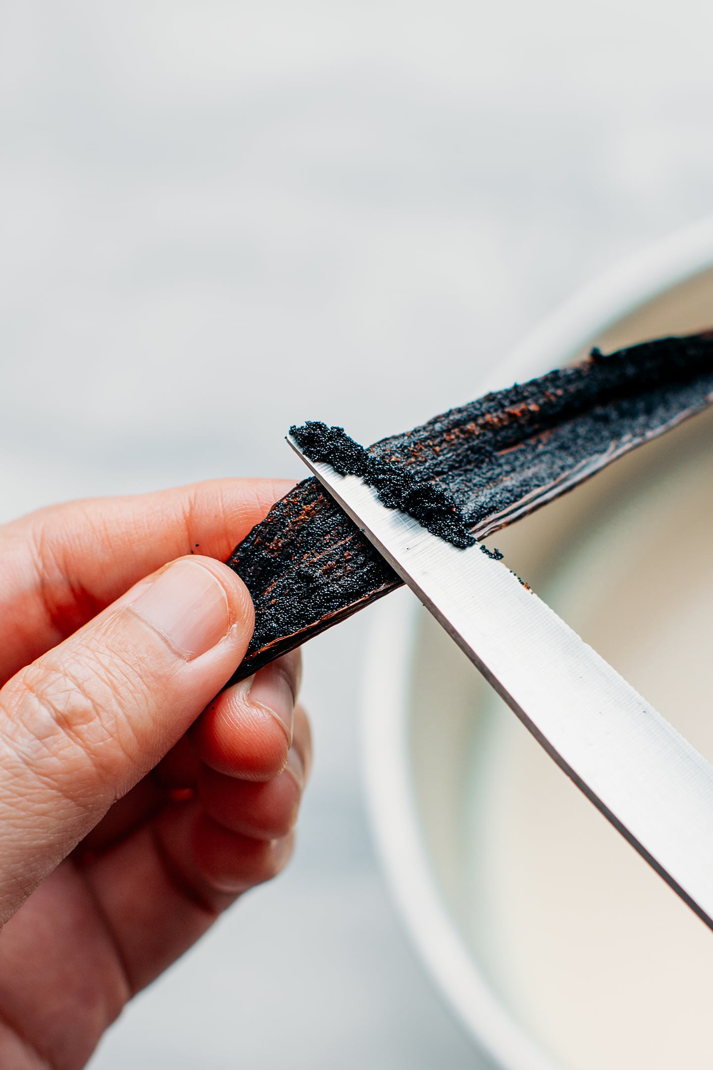 Scraping the seeds from a fresh vanilla bean.