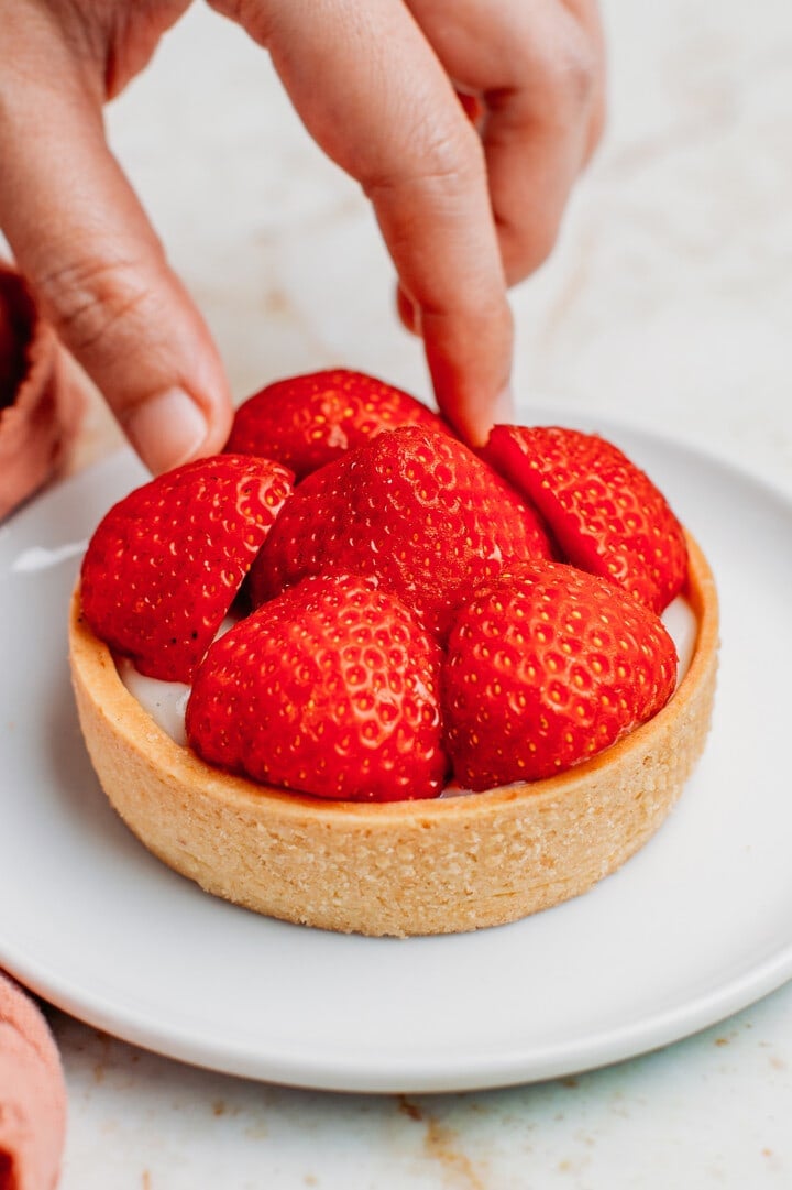 Arranging strawberries on top of a shortcrust pastry