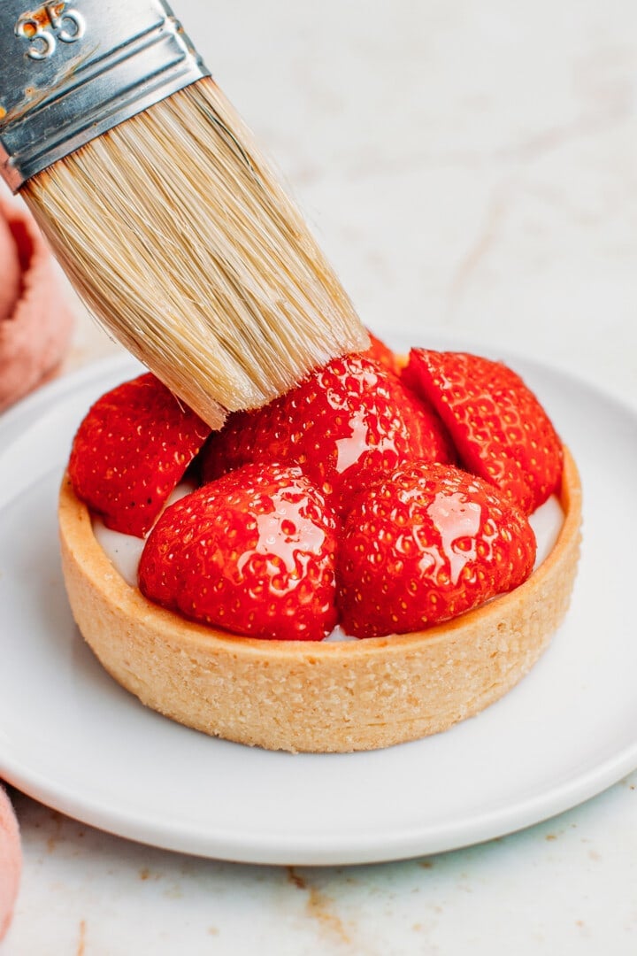 Brushing strawberries with syrup.