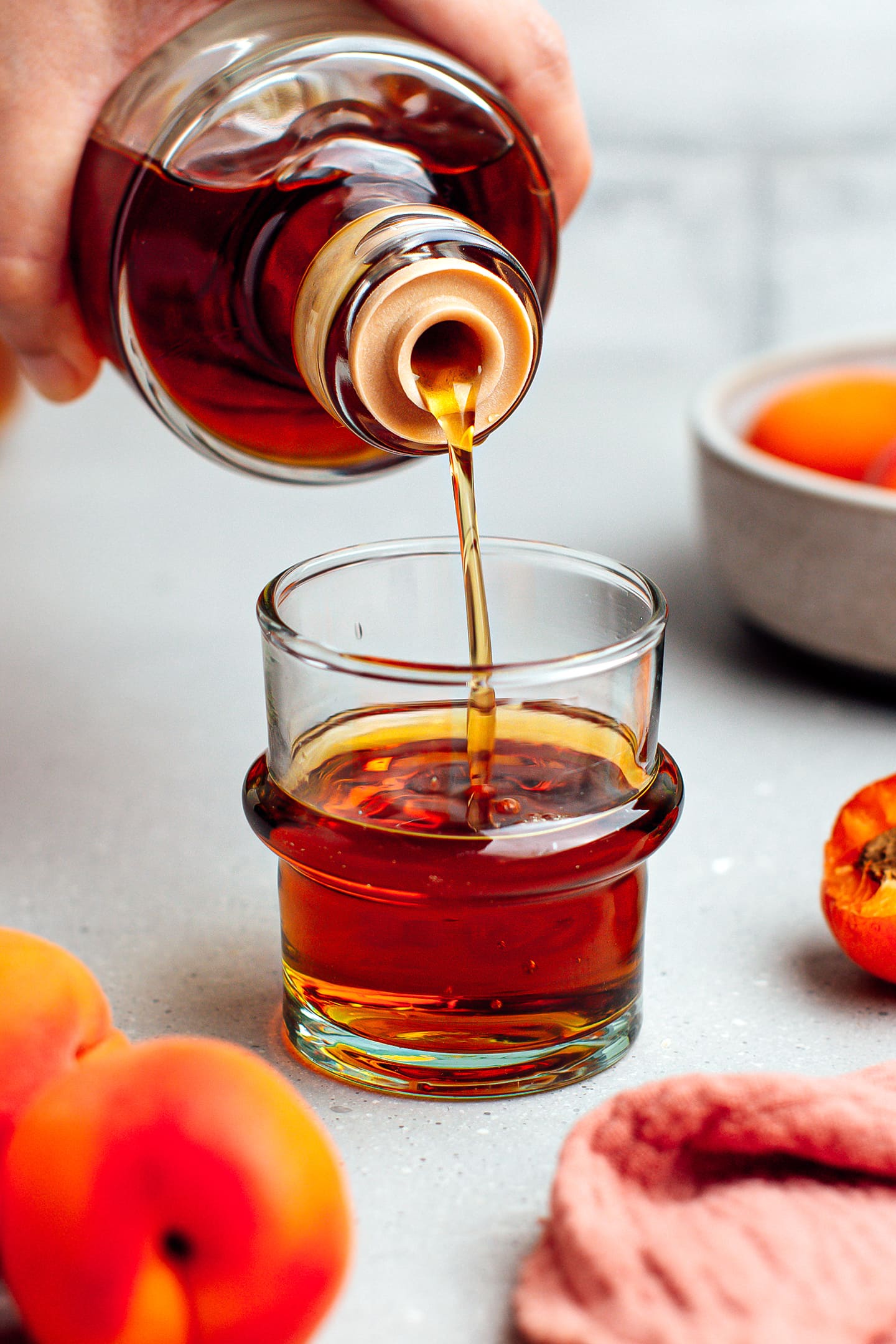 Pouring apricot liqueur into a glass.