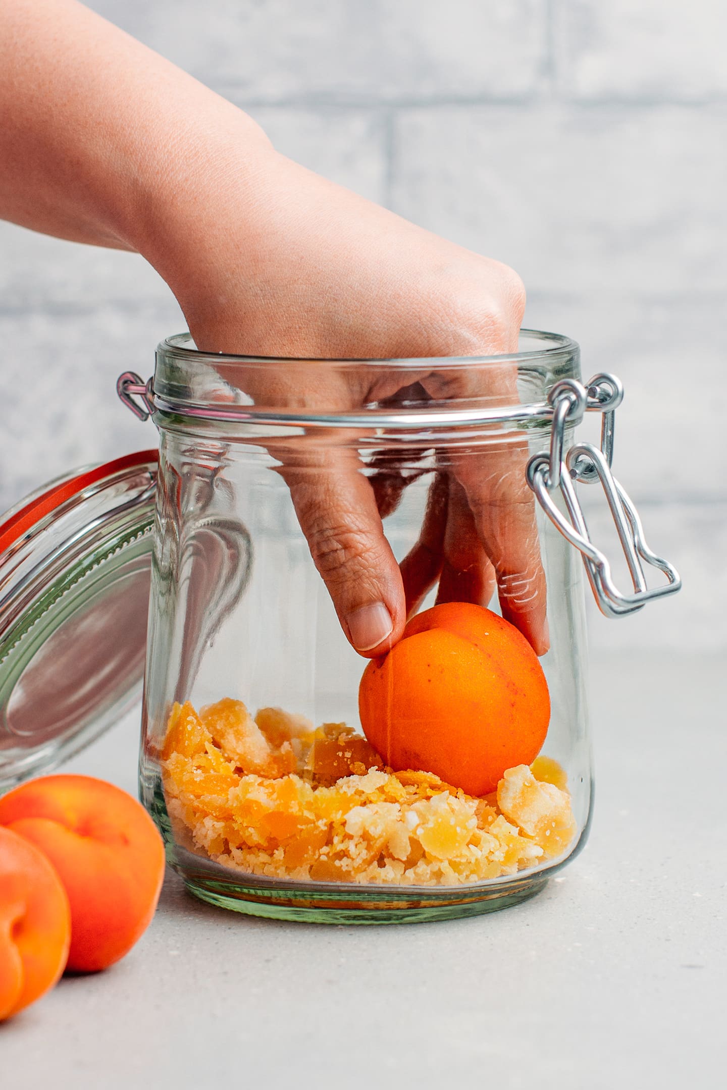 Placing fresh apricots in a glass jar.