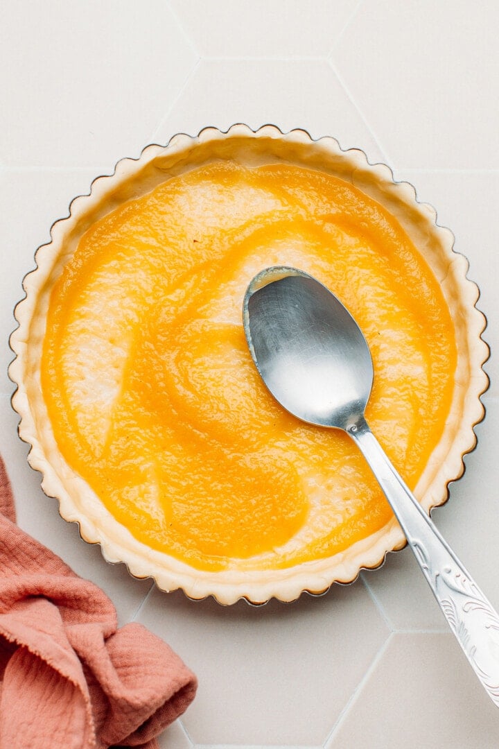 Spreading applesauce on a shortcrust pastry.