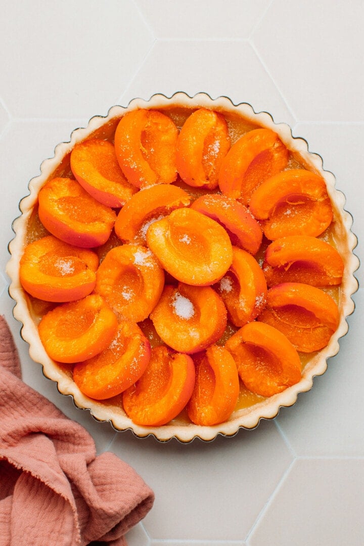 Uncooked apricot tart in a pan.
