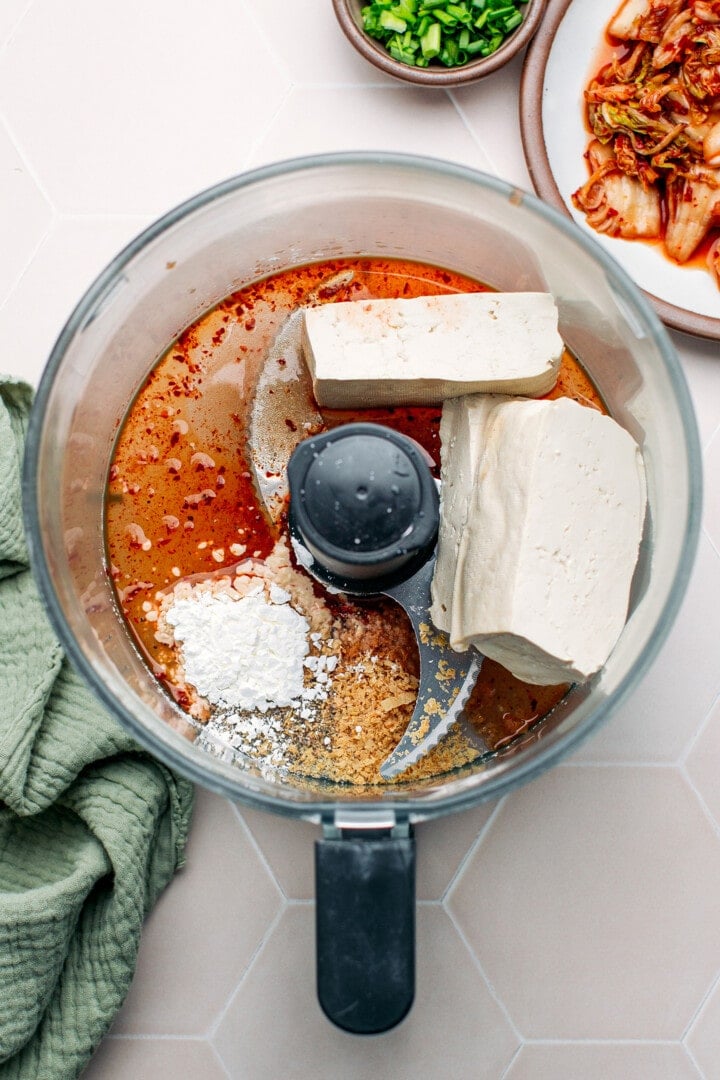 Tofu, kimchi brine, cornstarch, and nutritional yeast in a food processor.