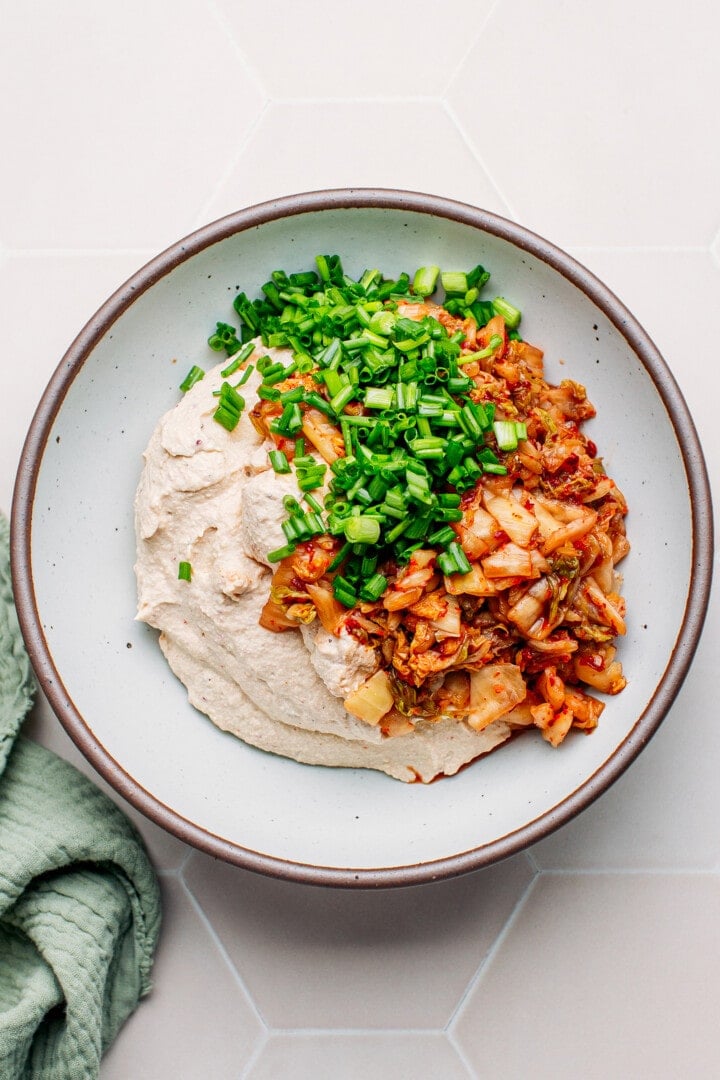 Tofu cream, kimchi, and green onions in a bowl.