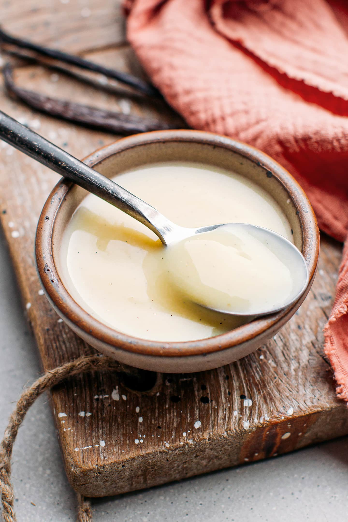 Spoonful of vegan crème anglaise with fresh vanilla beans.