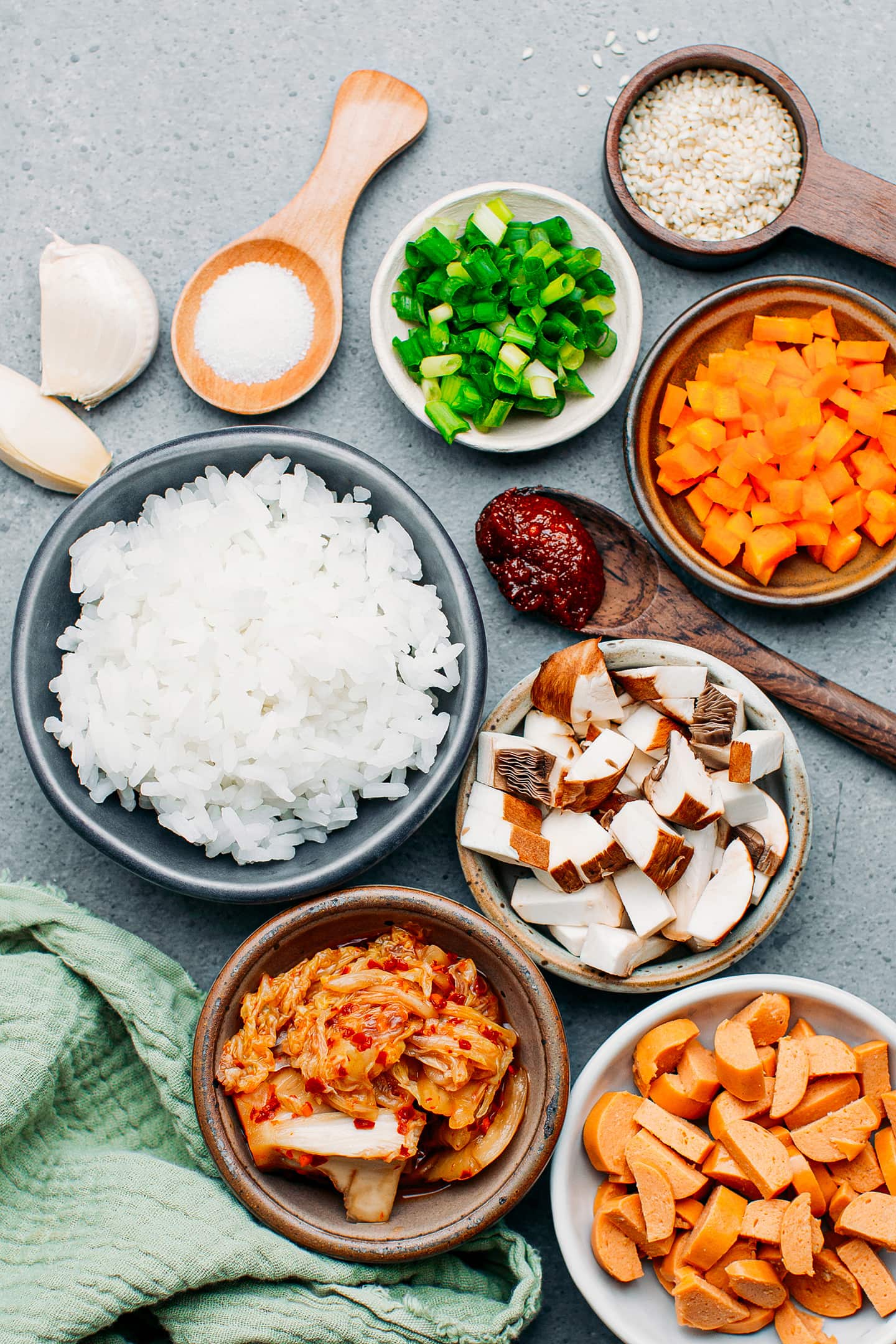 Ingredients like kimchi, cooked rice, carrots, and mushrooms.