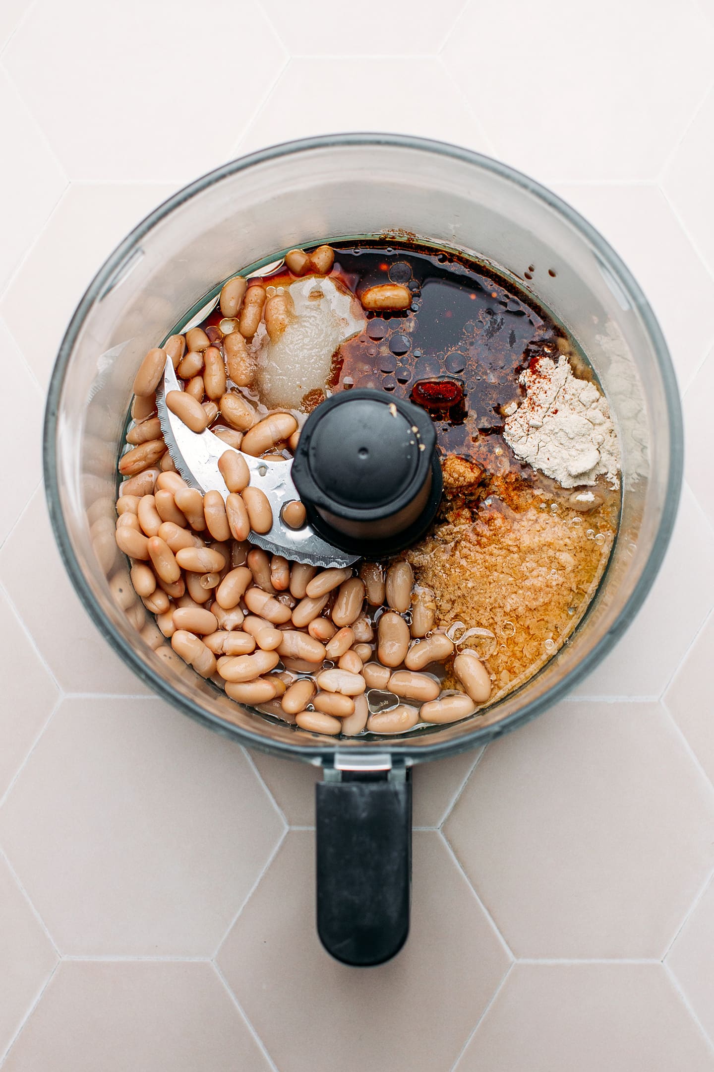 Cooked white beans, nutritional yeast, onion powder, and soy sauce in a food processor.