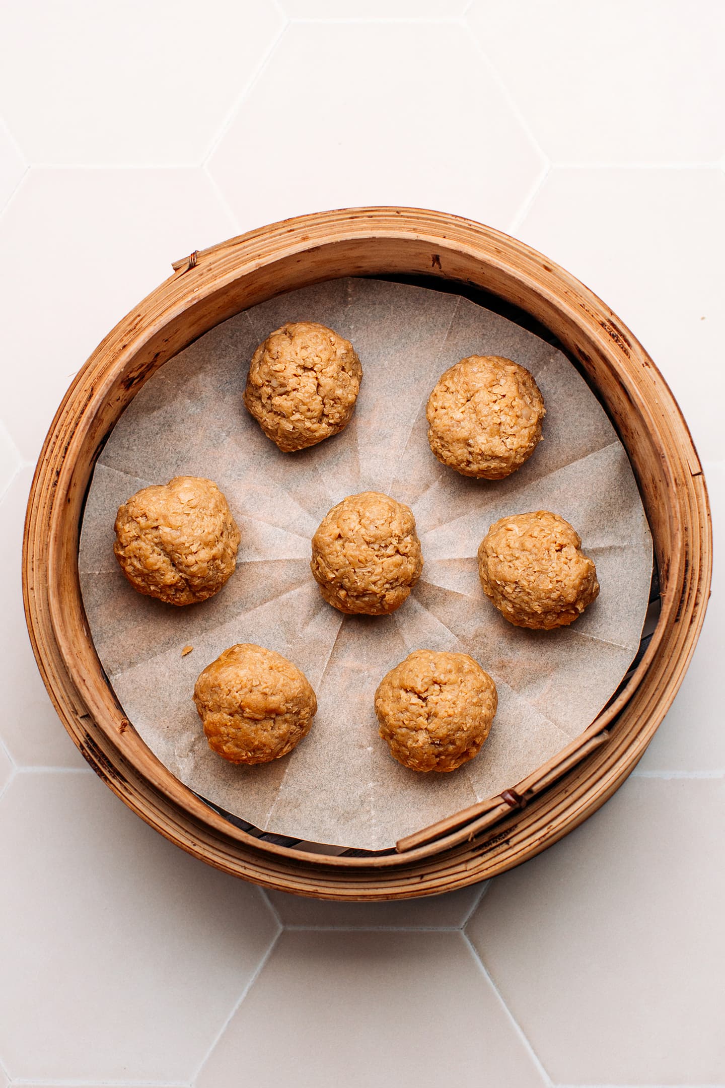 Vegan meatballs in a bamboo basket steamer.