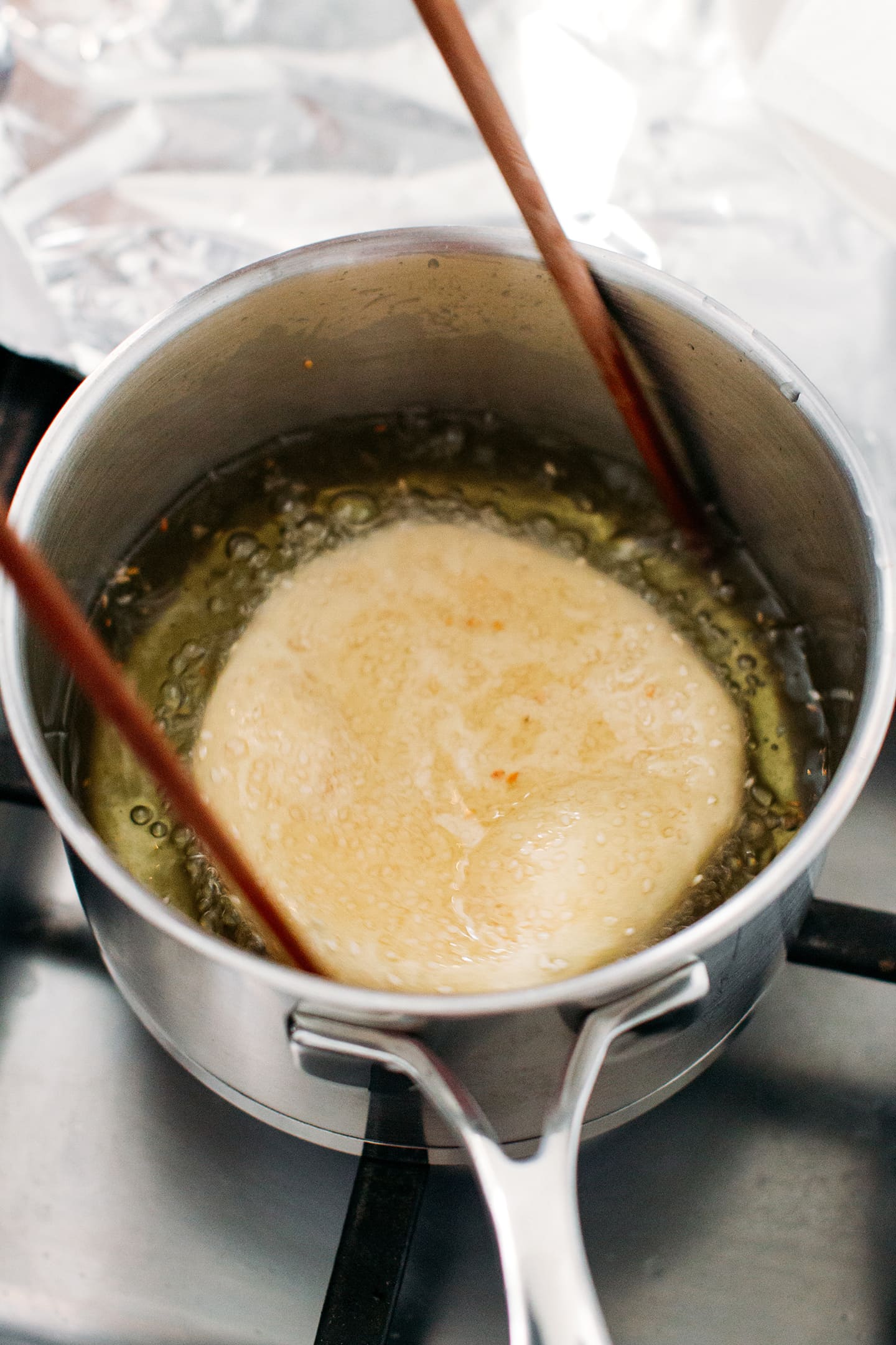 Frying a sesame donut in oil.