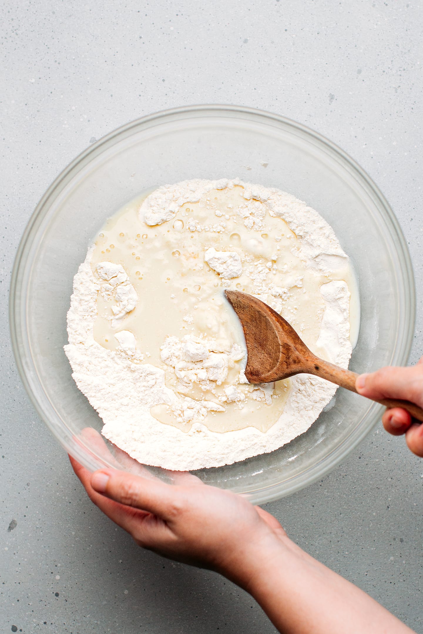 Whisking flour, sugar, and almond milk.
