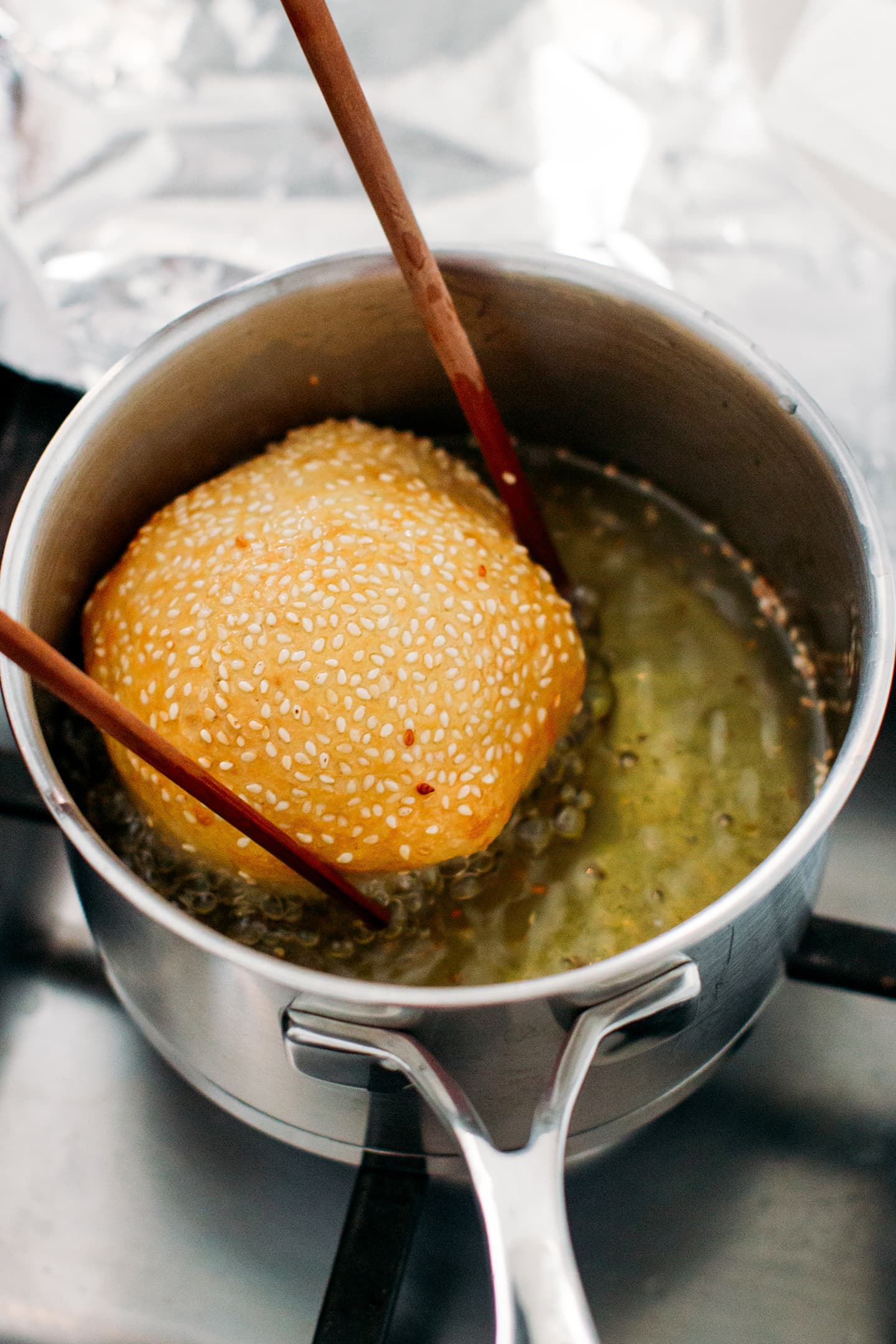 Frying a sesame donut.