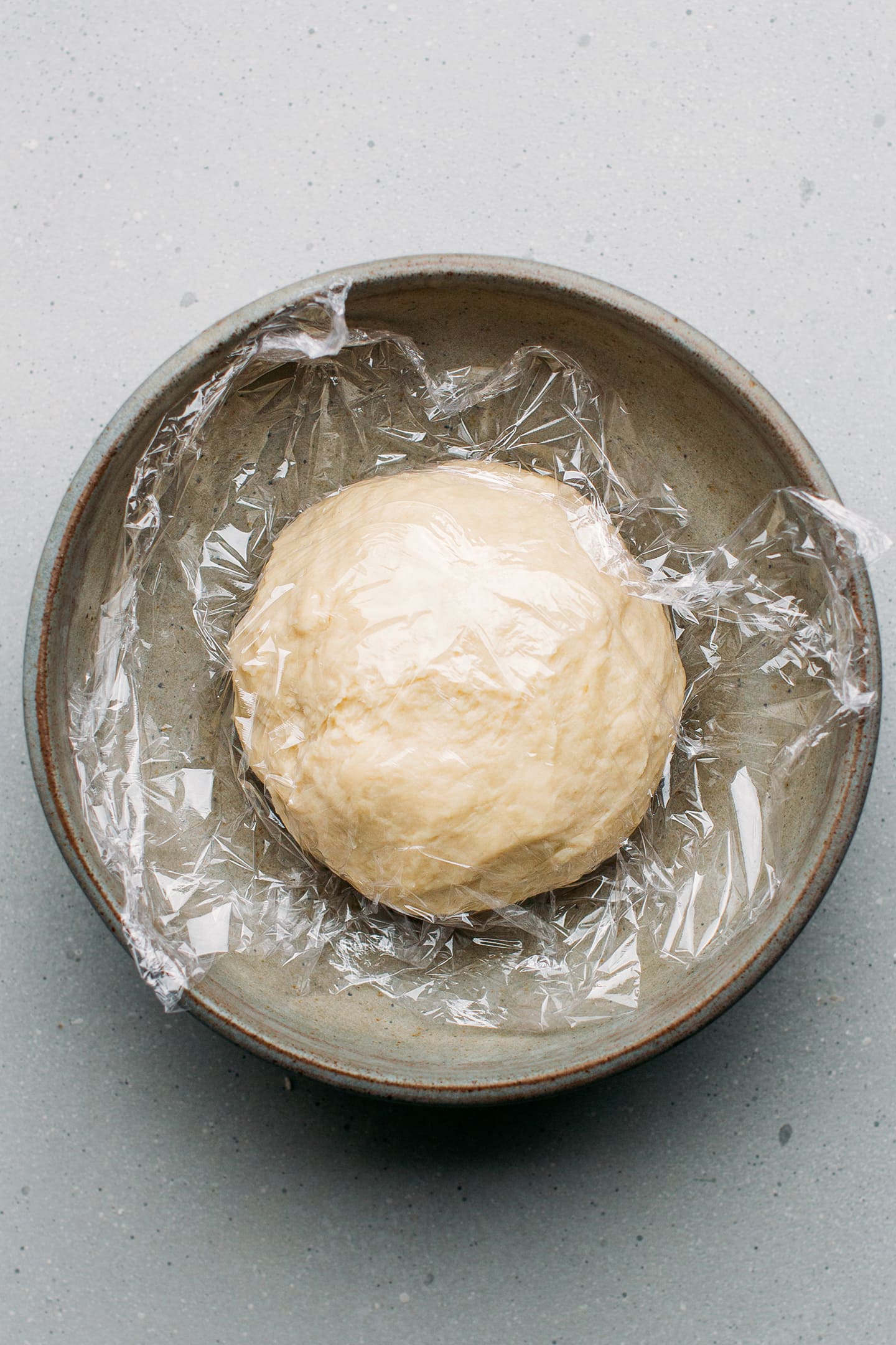 Dough covered with plastic wrap.