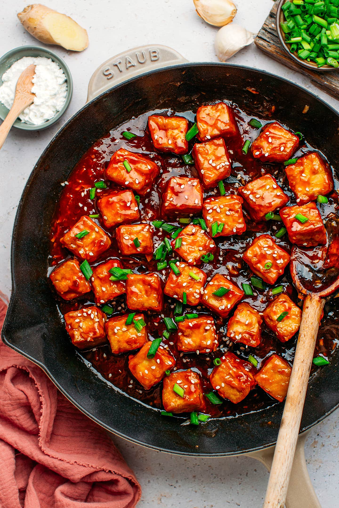 Tofu tossed with a sweet and salty sauce in a skillet.