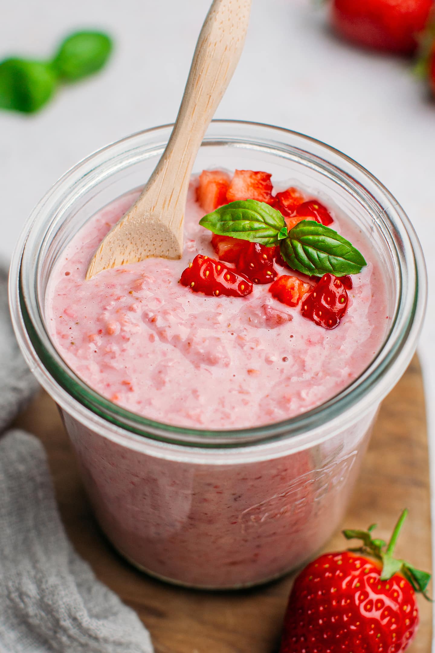 Strawberry oats topped with diced strawberries in a jar.