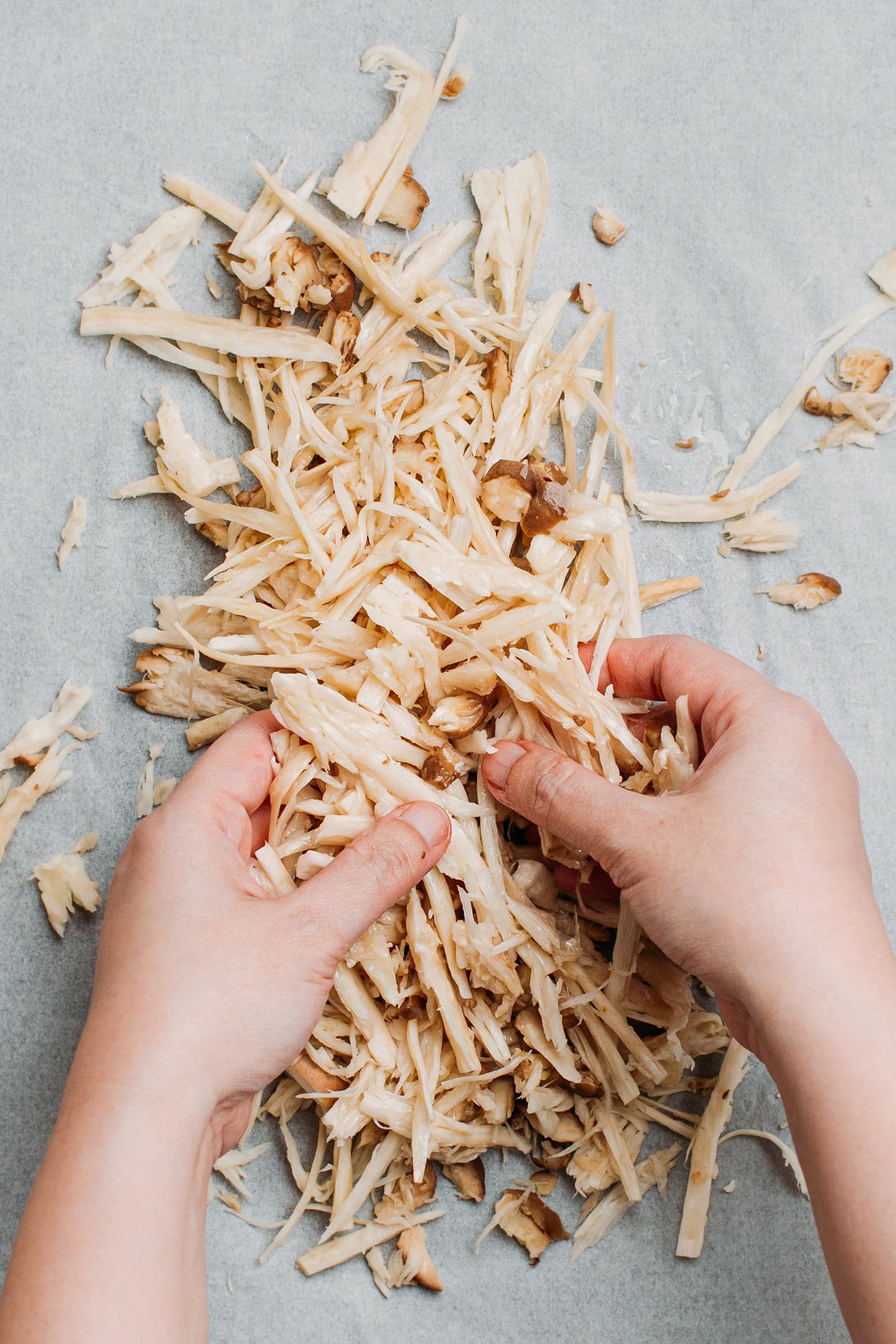 Tossing shredded mushrooms with oil.