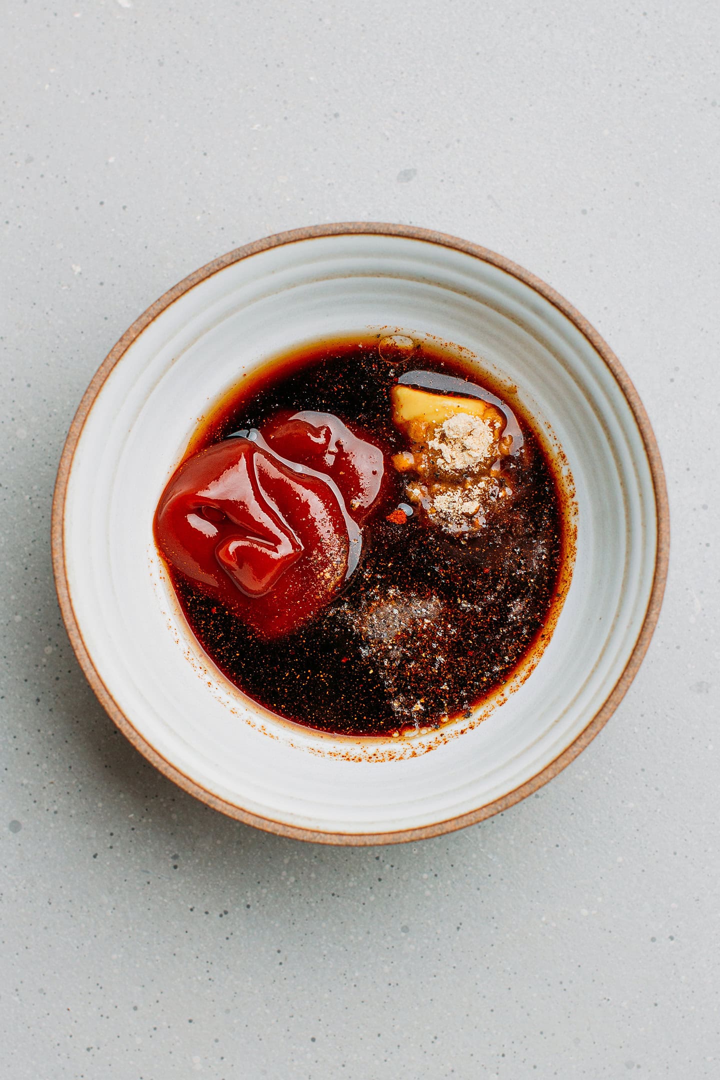 Ketchup, apple cider vinegar, sugar, and mustard in a small bowl.