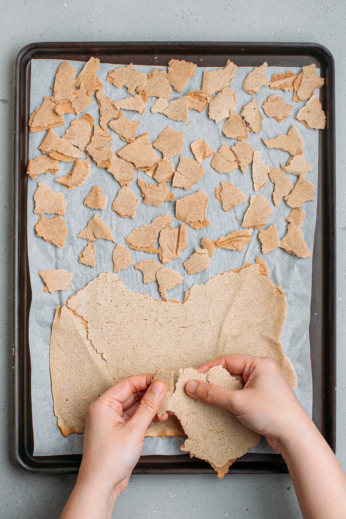 Breaking a thin buckwheat dough into flakes.