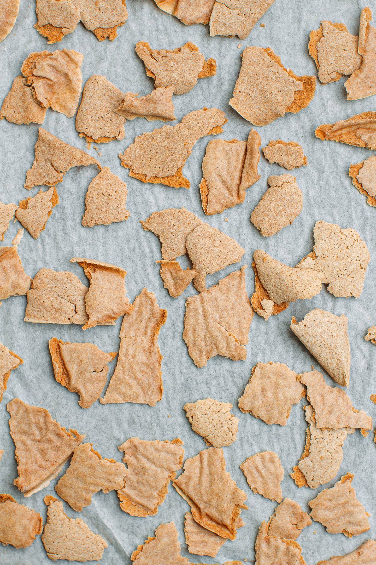 Close-up of buckwheat flakes on a baking sheet.