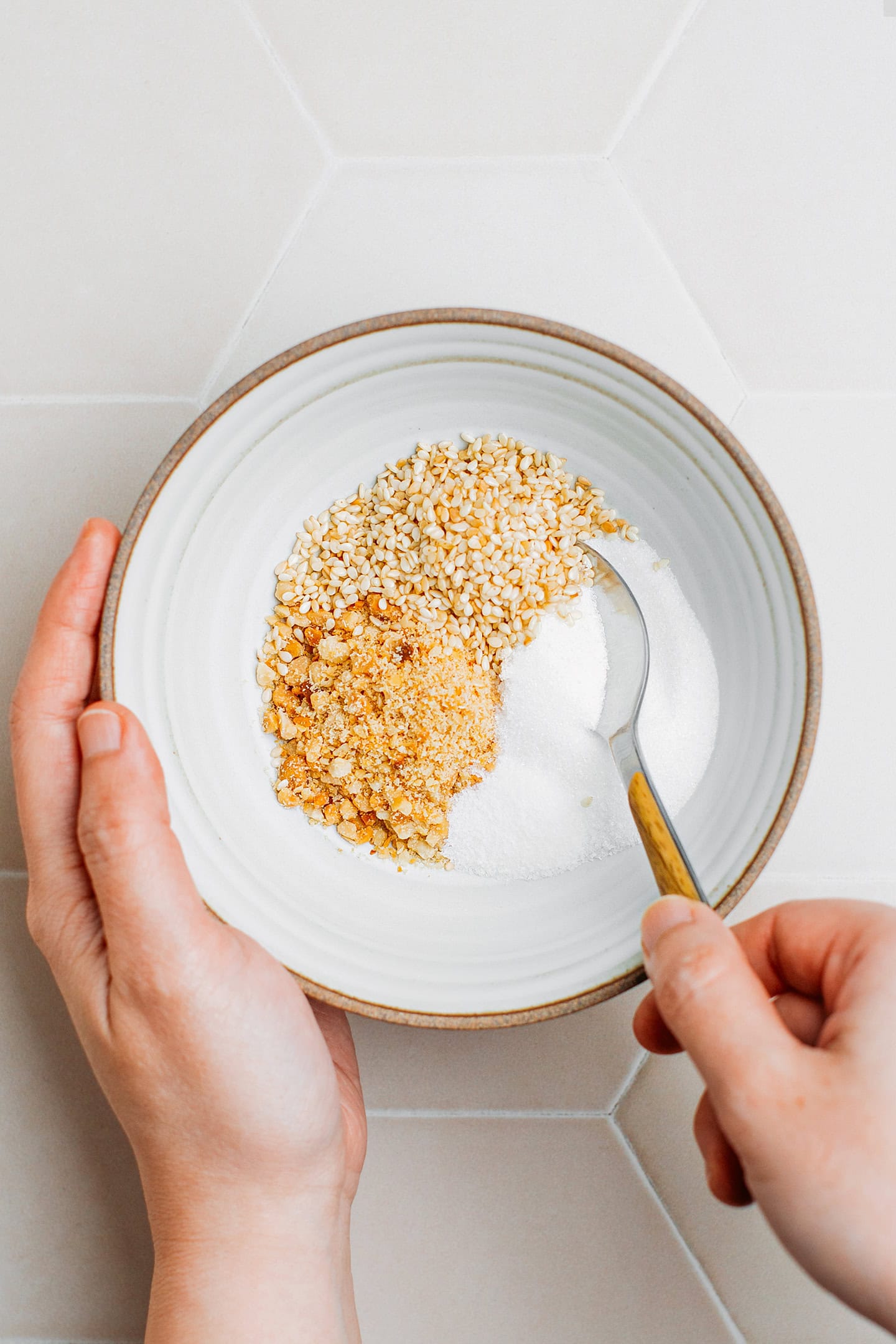Roasted peanuts, toasted sesame seeds, sugar, and salt in a bowl.