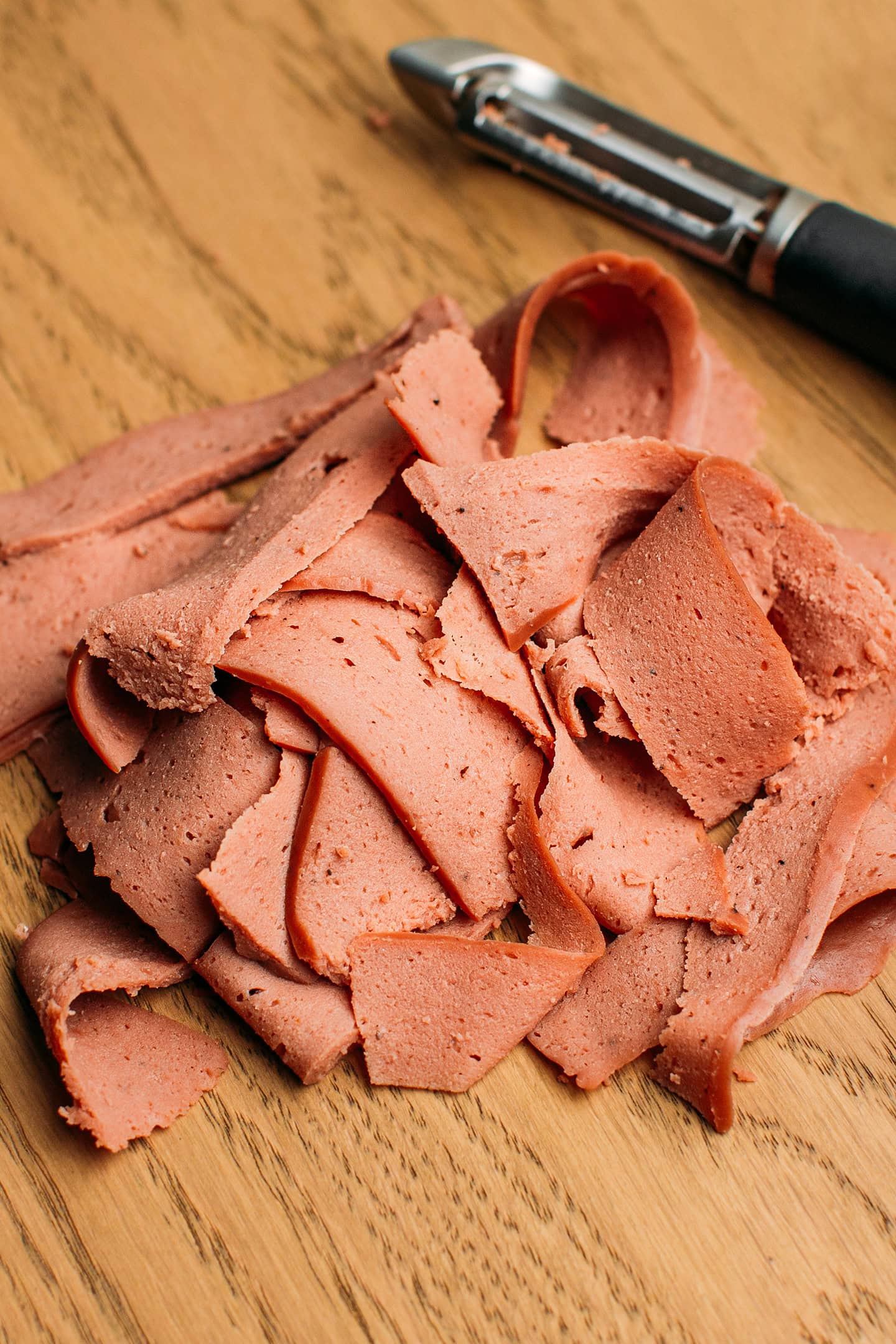 Thinly sliced seitan on a cutting board.