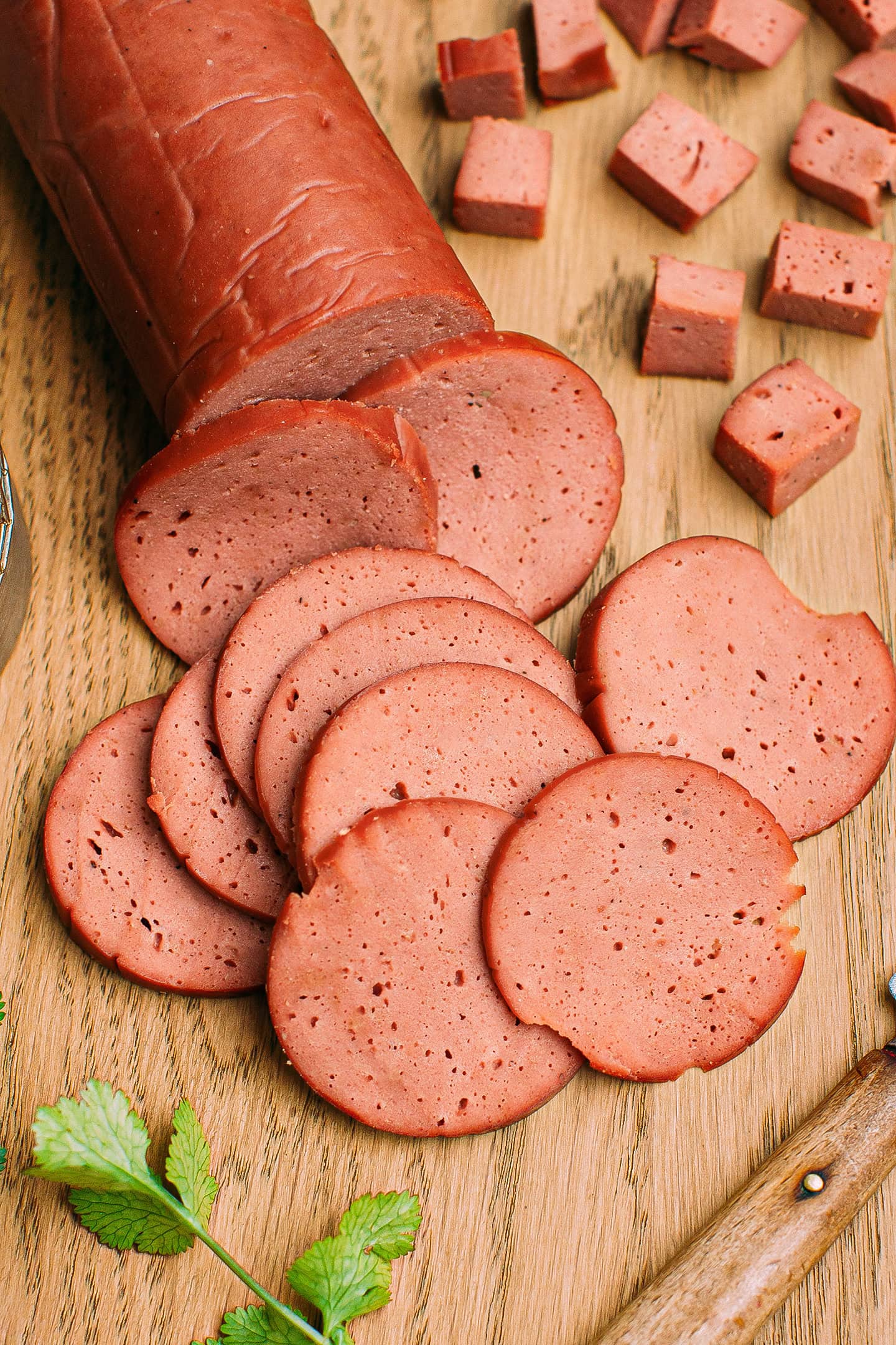 Slices of smoked seitan on a cutting board.