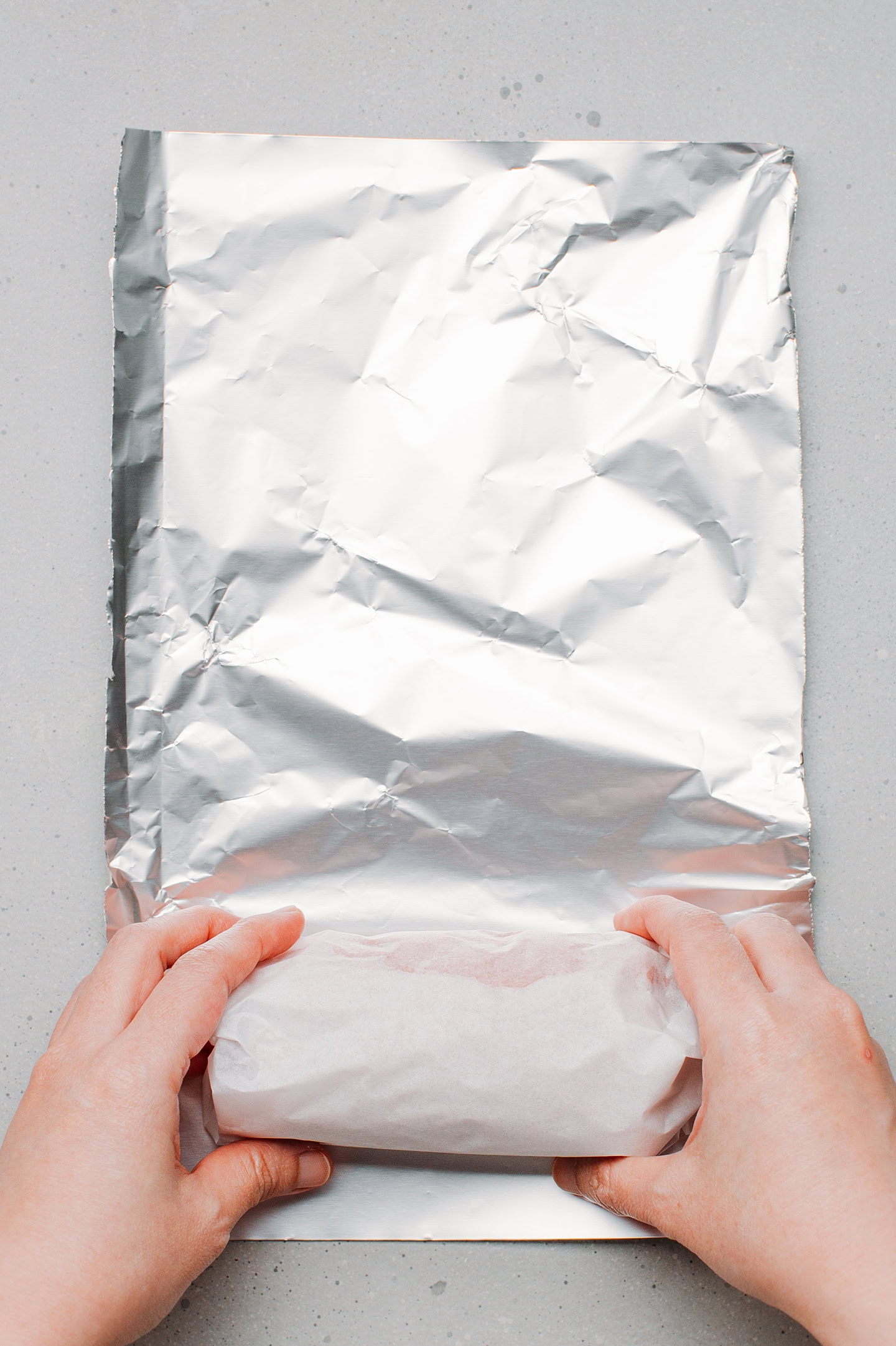 Wrapping seitan loaf in aluminum foil.