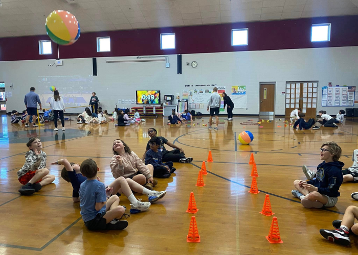 Children playing sitting volleyball in a gymnasium