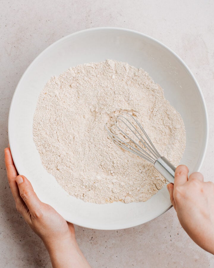 Whisking flour, light brown sugar, cinnamon, and baking powder in a bowl.