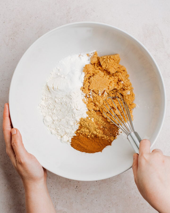 Whisking flour, brown sugar, and spices in a mixing bowl.
