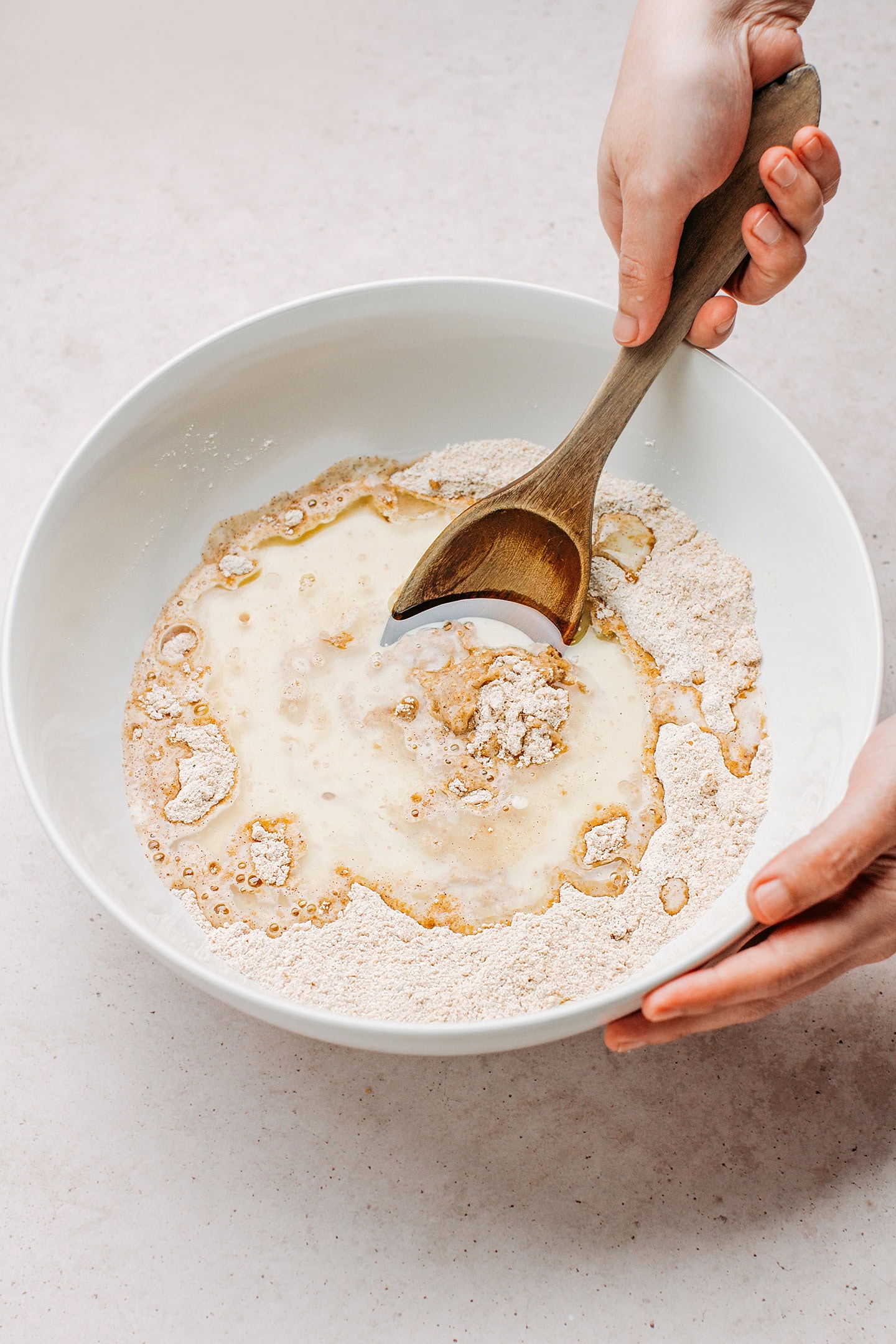 Mixing carrot cake batter in a large mixing bowl.