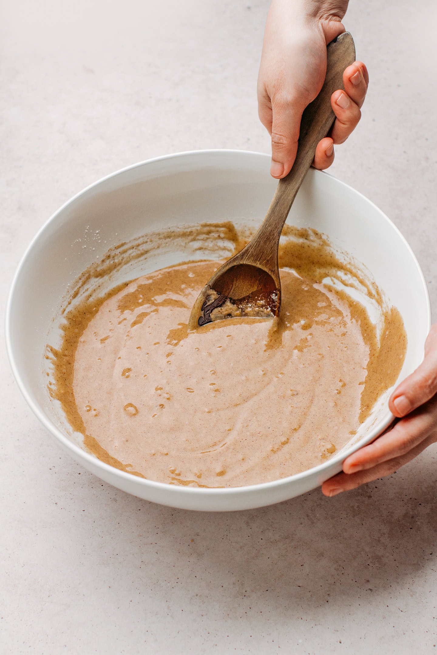 Mixing carrot cake batter in a bowl.