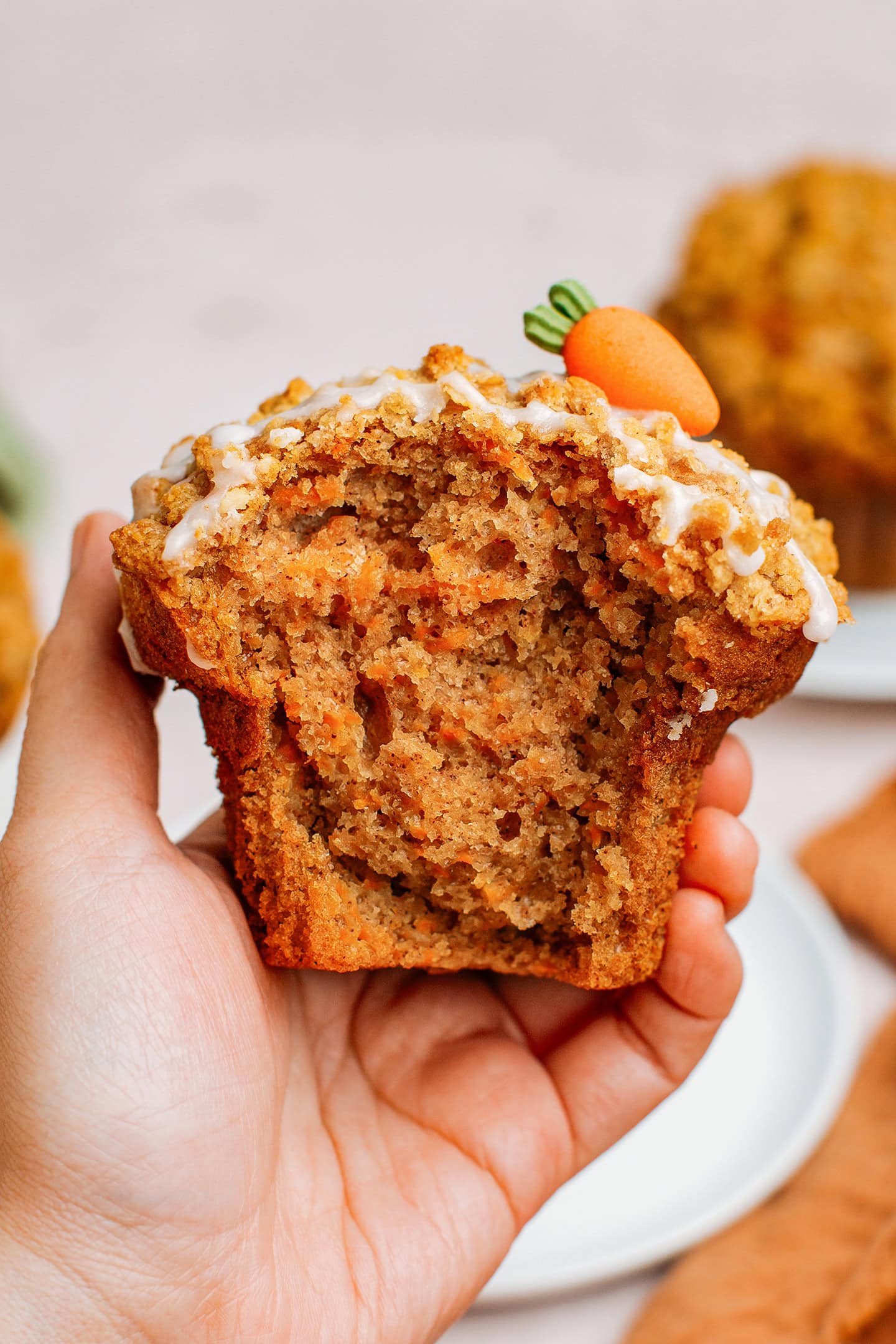Holding a carrot cake muffin filled with grated carrots.