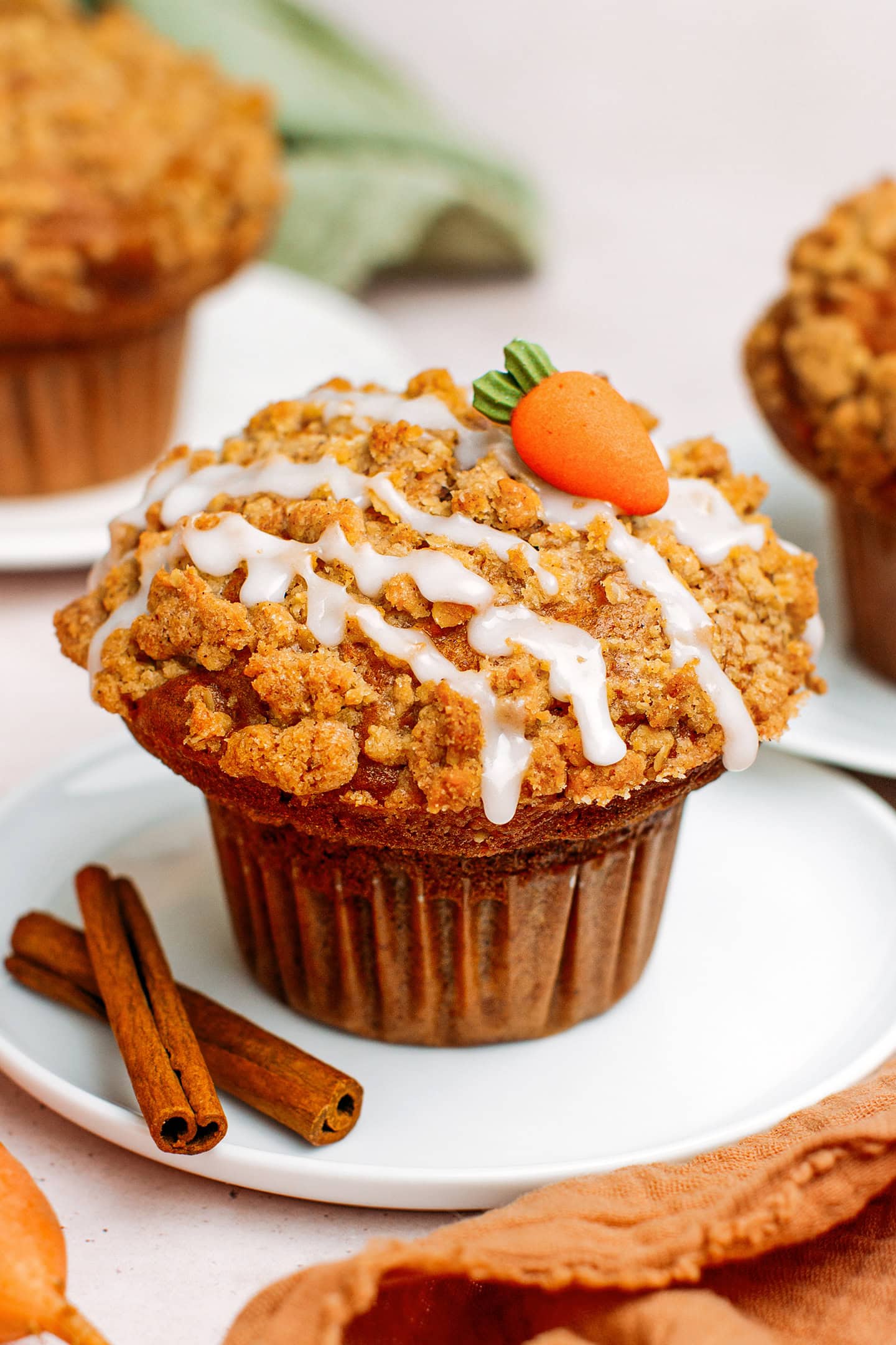 Carrot cake muffin topped with oat crumble and sugar glaze.