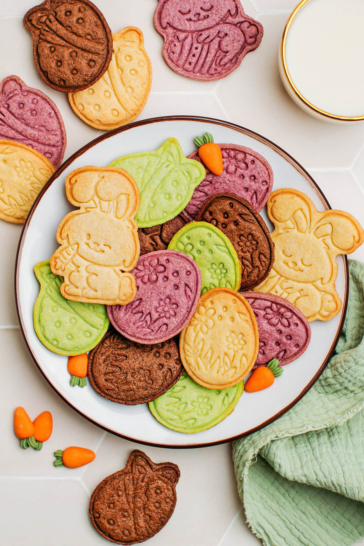 Colorful sugar cookies shaped in egg and bunnies on a plate.
