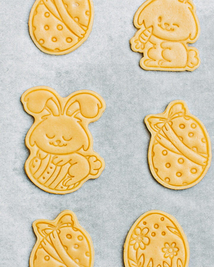 Uncooked easter sugar cookies on a baking sheet.