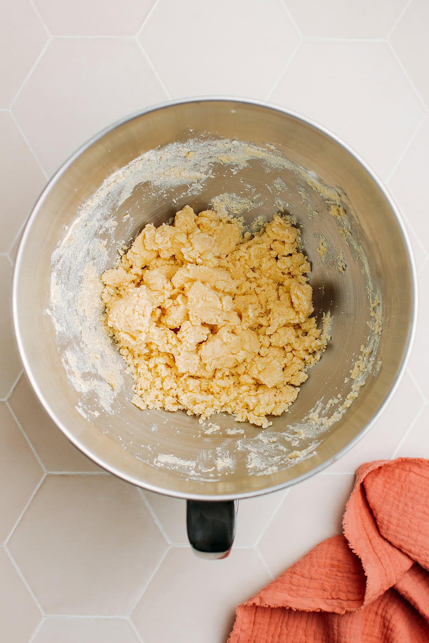 Sugar cookie dough in the bowl of a stand mixer.