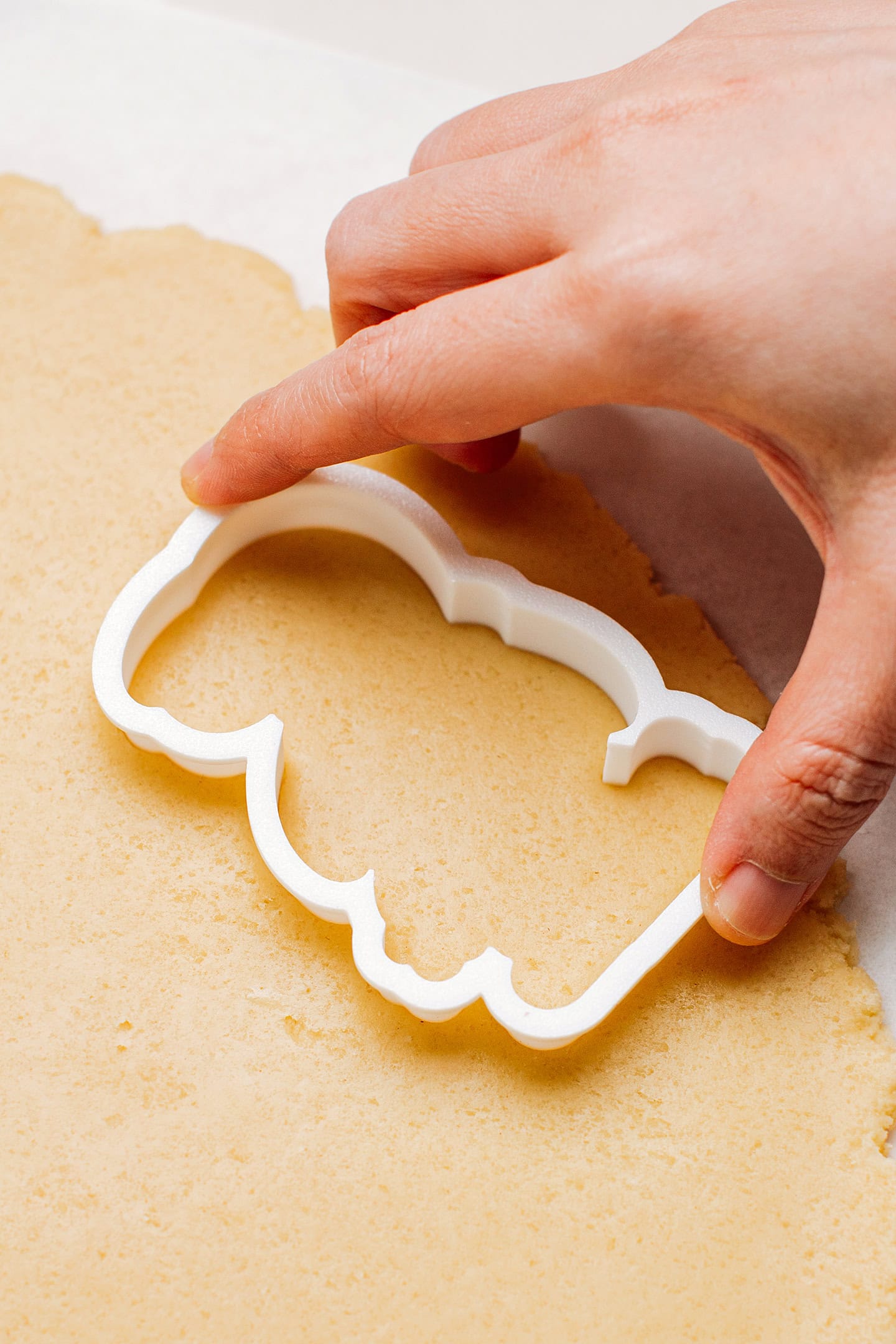Cutting out a sugar cookie using a cookie cutter.