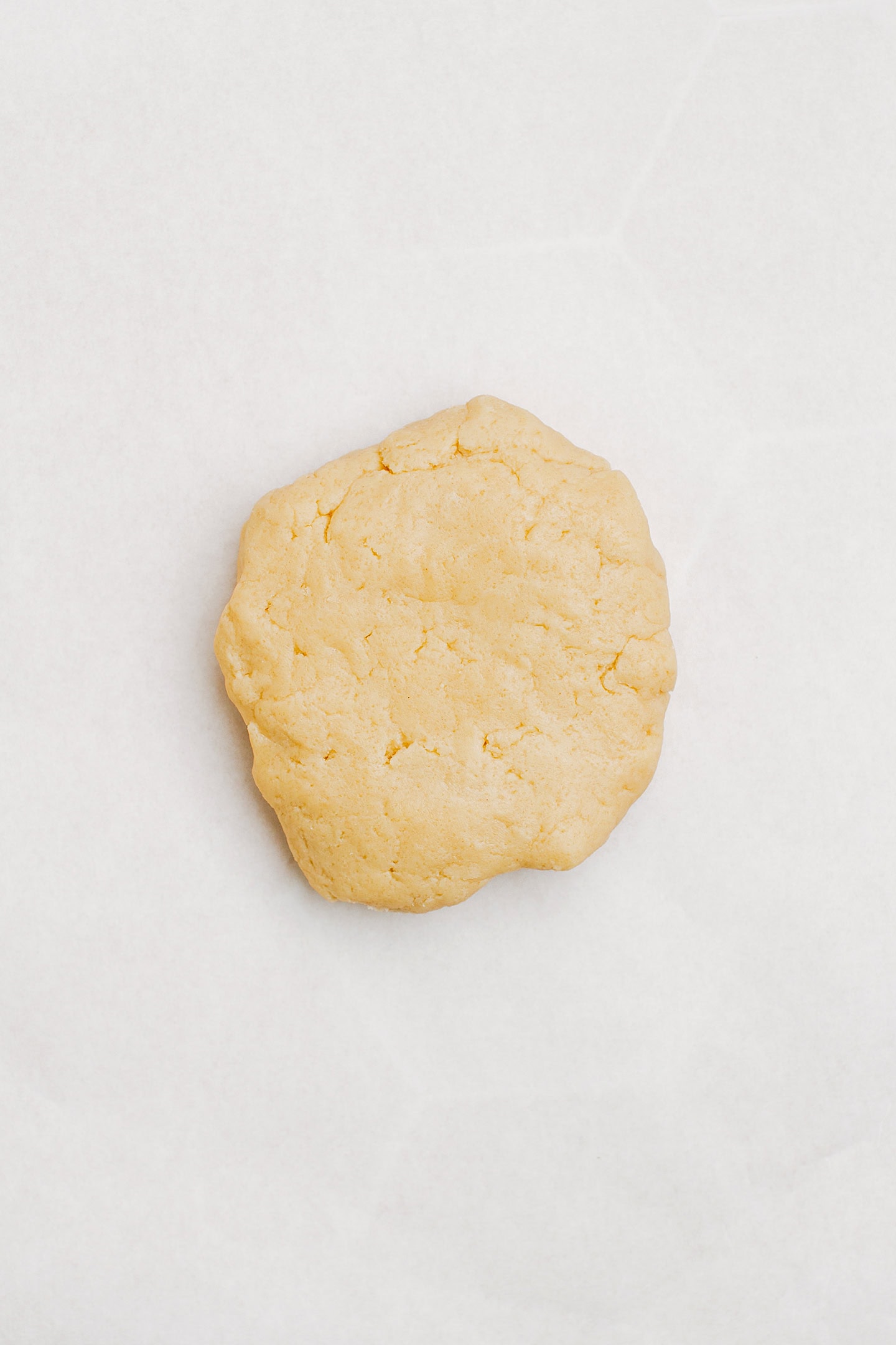 Ball of dough on a piece of parchment paper.