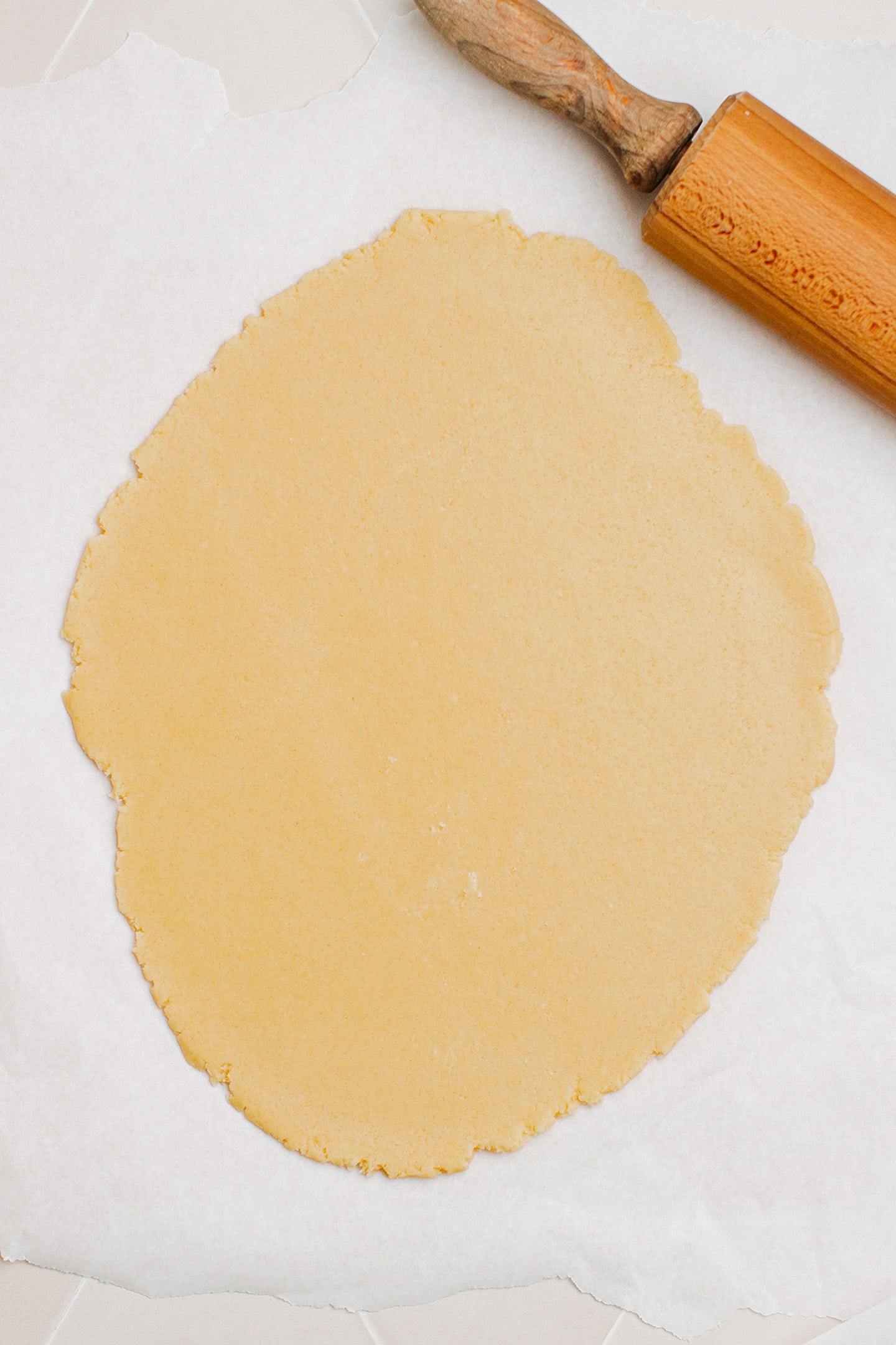 Flattened cookie dough on a piece of parchment paper.