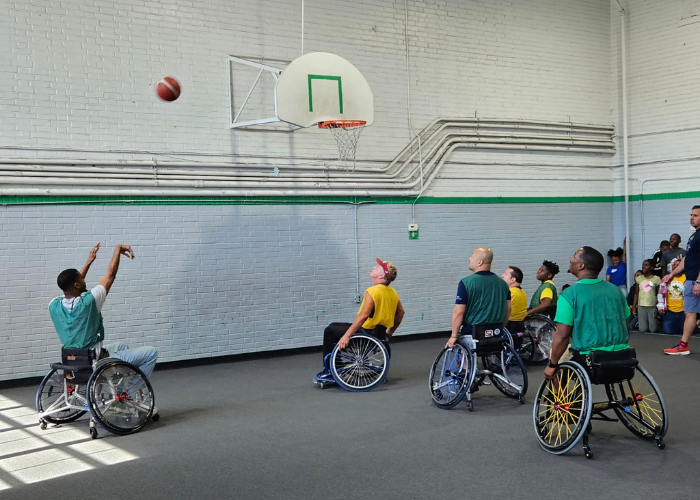 A group of individuals playing wheelchair basketball in a gymnasium