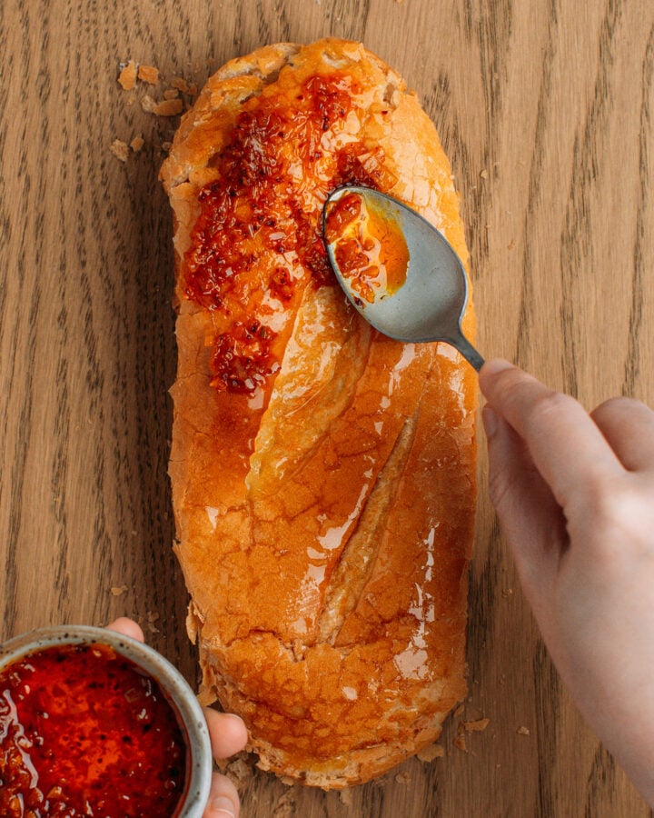 Spreading saté on banh mi bread.