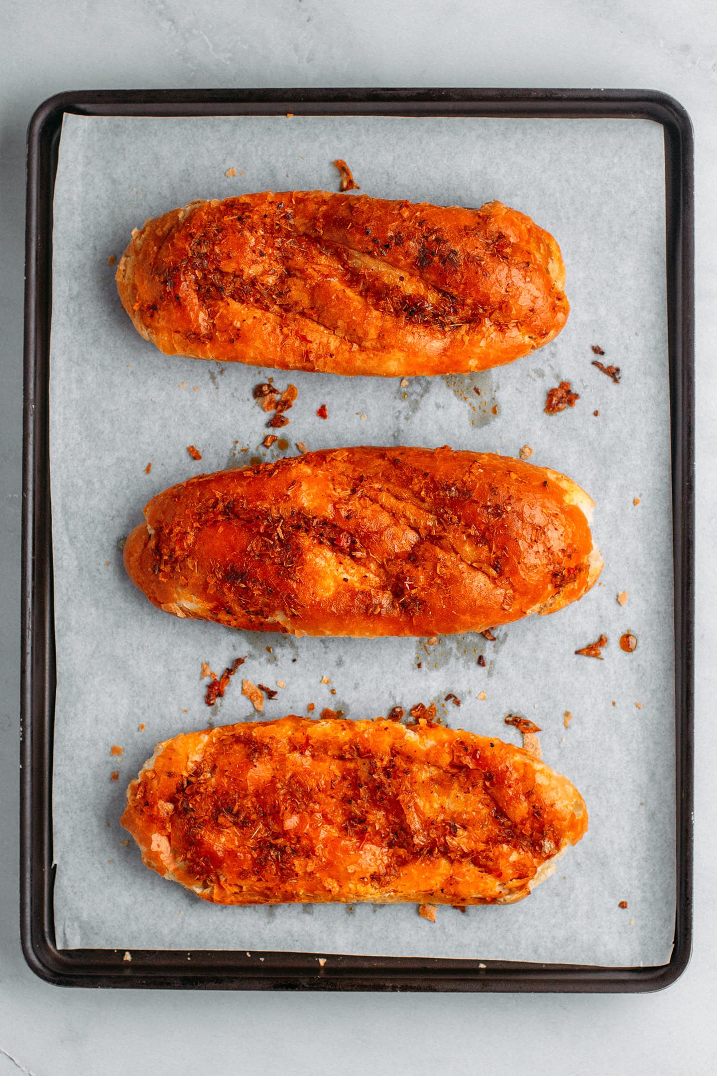 Grilled banh mi bread on a baking sheet.