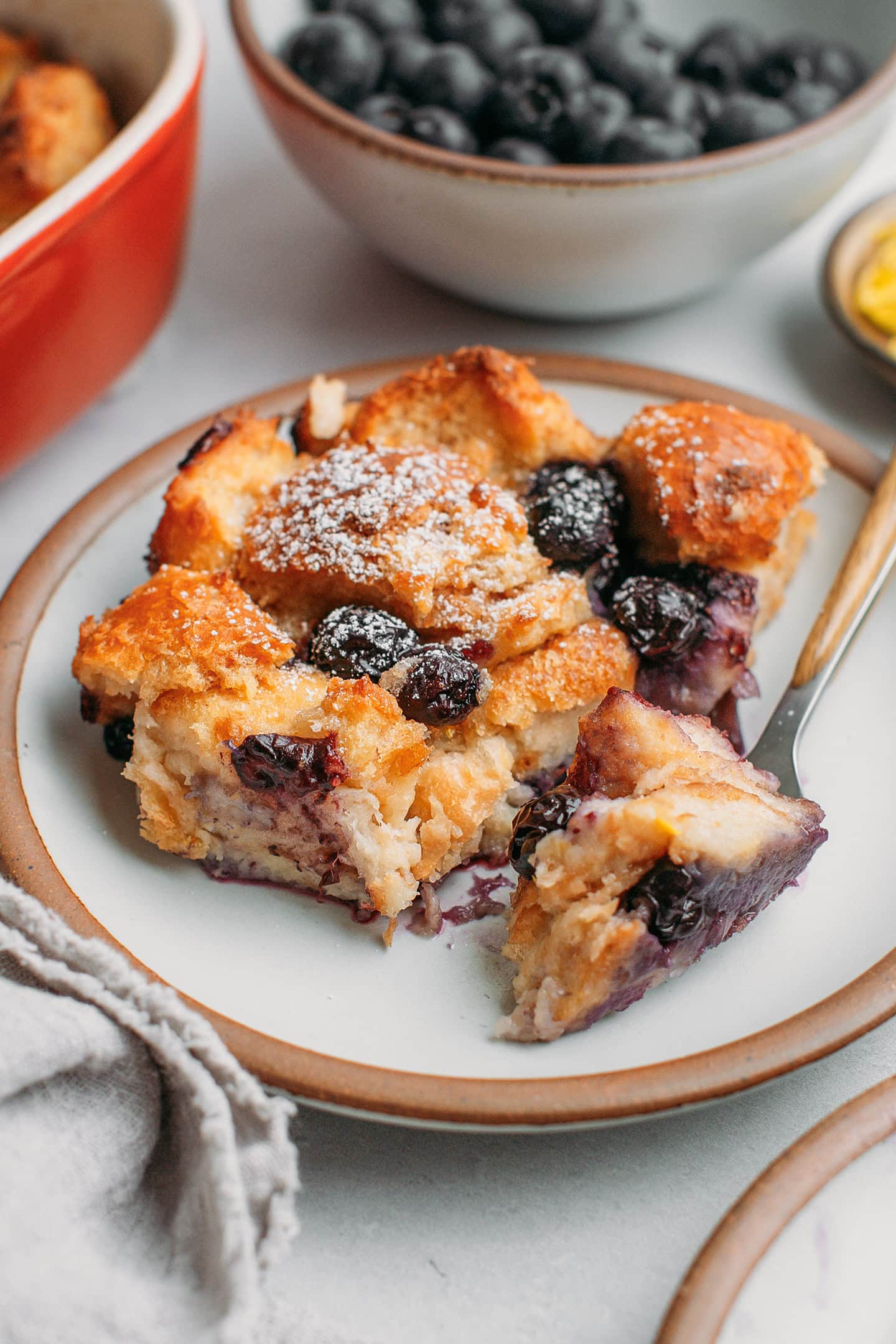 Close-up of a slice of bread pudding with blueberries.