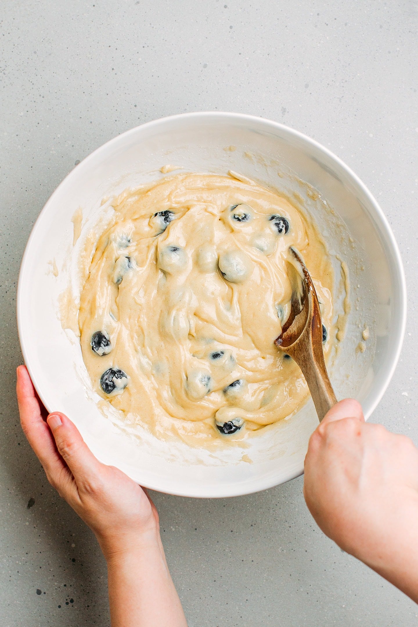 Incorporating blueberries into a batter.