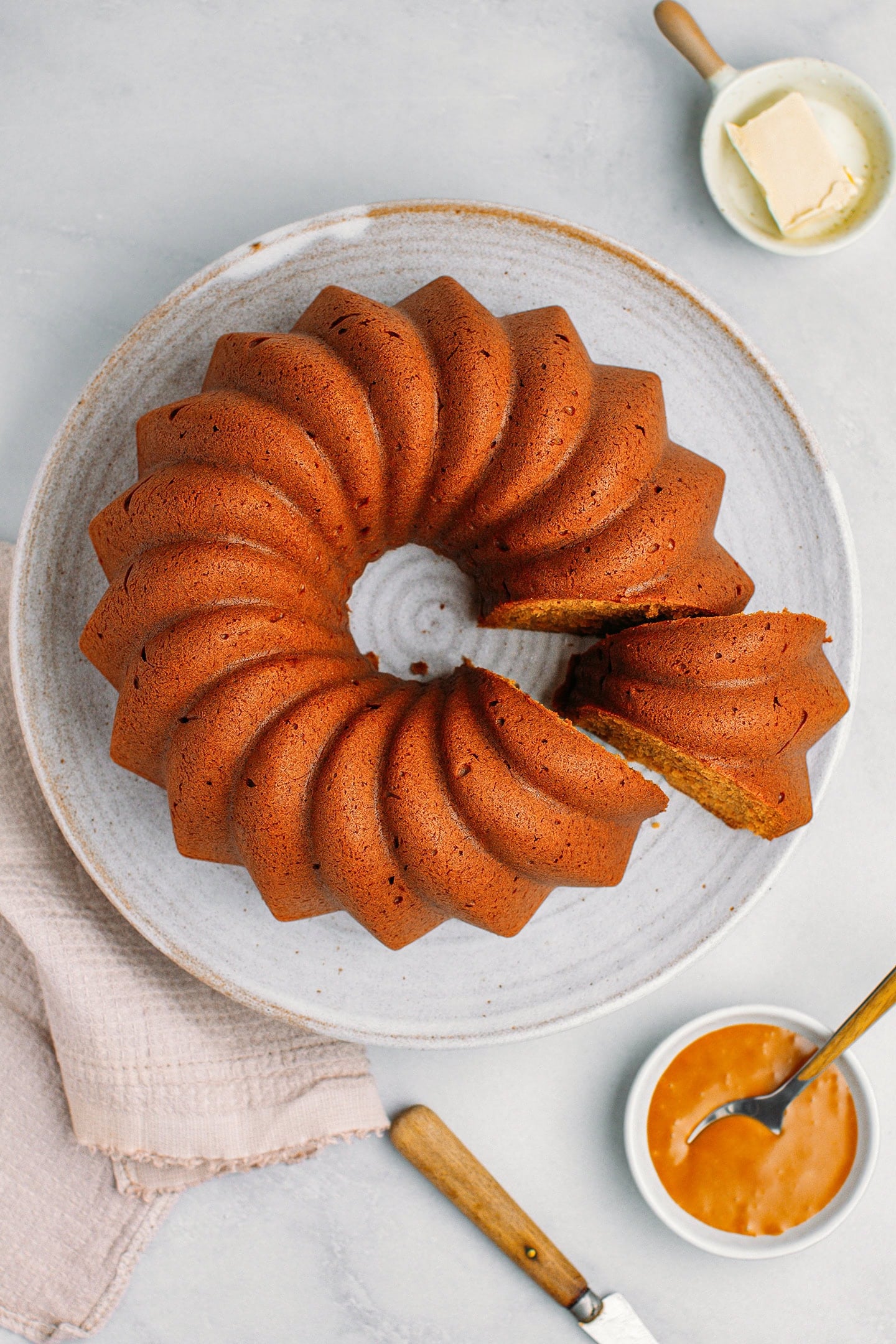 Top view of caramel bundt cake on a large serving plate.